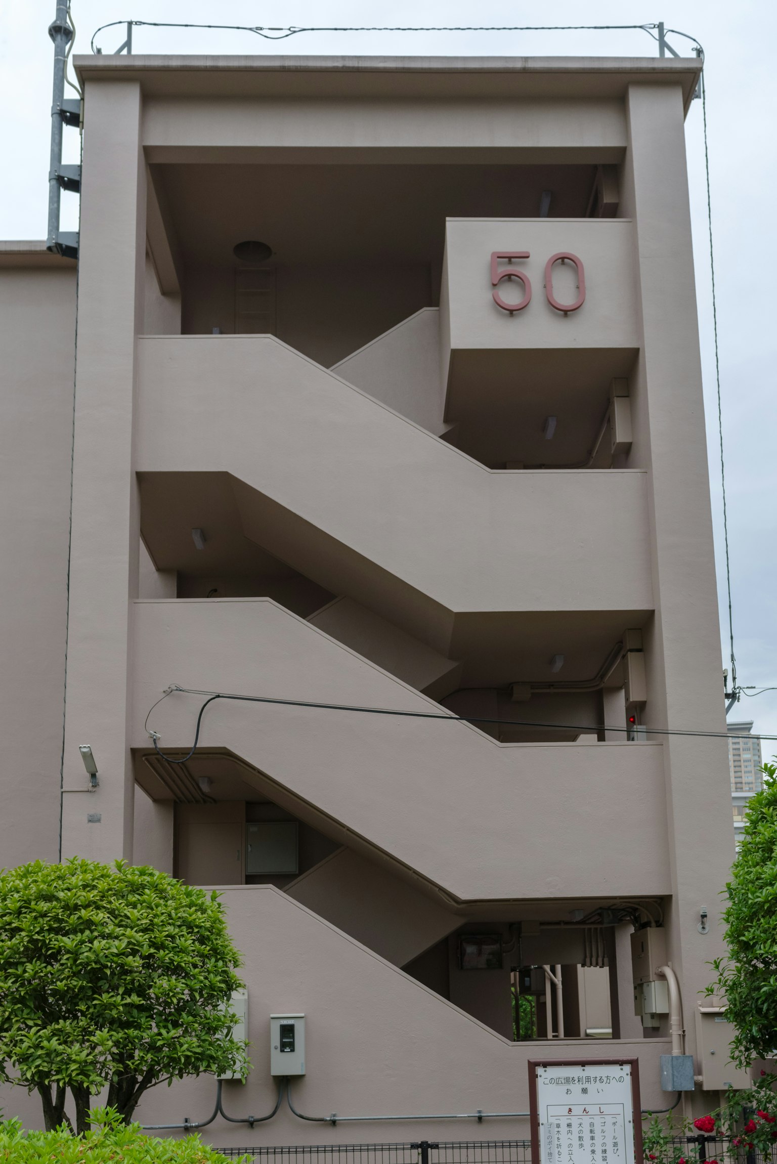 Exterior view of a building with stairs and the number 50 displayed