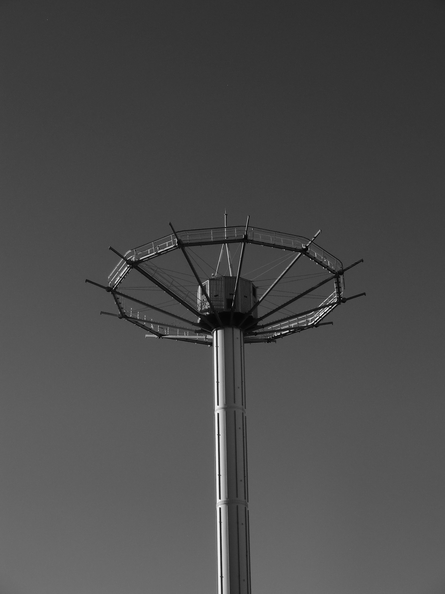 Diseño único de la parte superior de una torre contra un cielo en blanco y negro