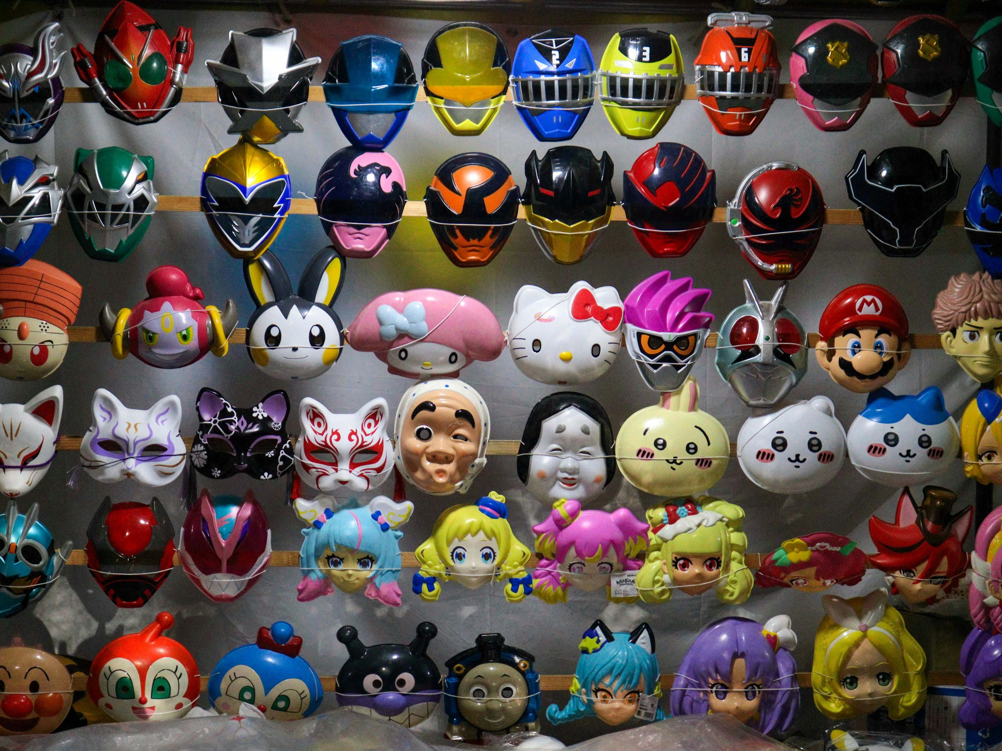 カラフルなキャラクターマスクの棚に並ぶフィギュア