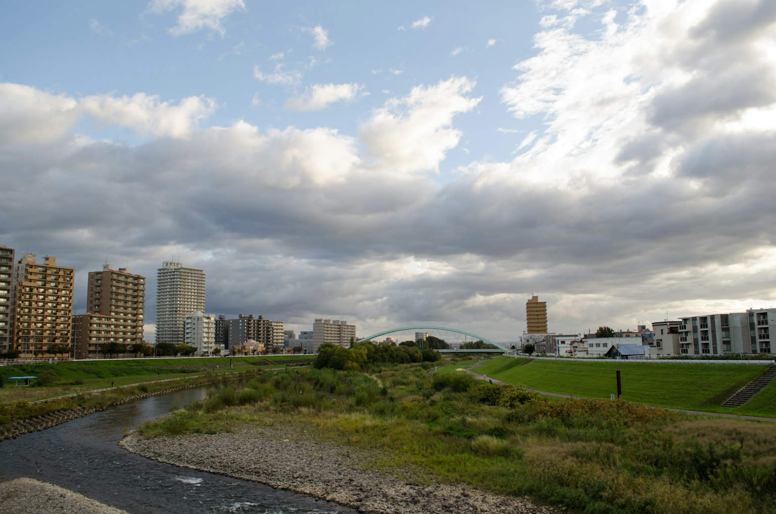 Paesaggio urbano con edifici e un fiume sotto un cielo nuvoloso