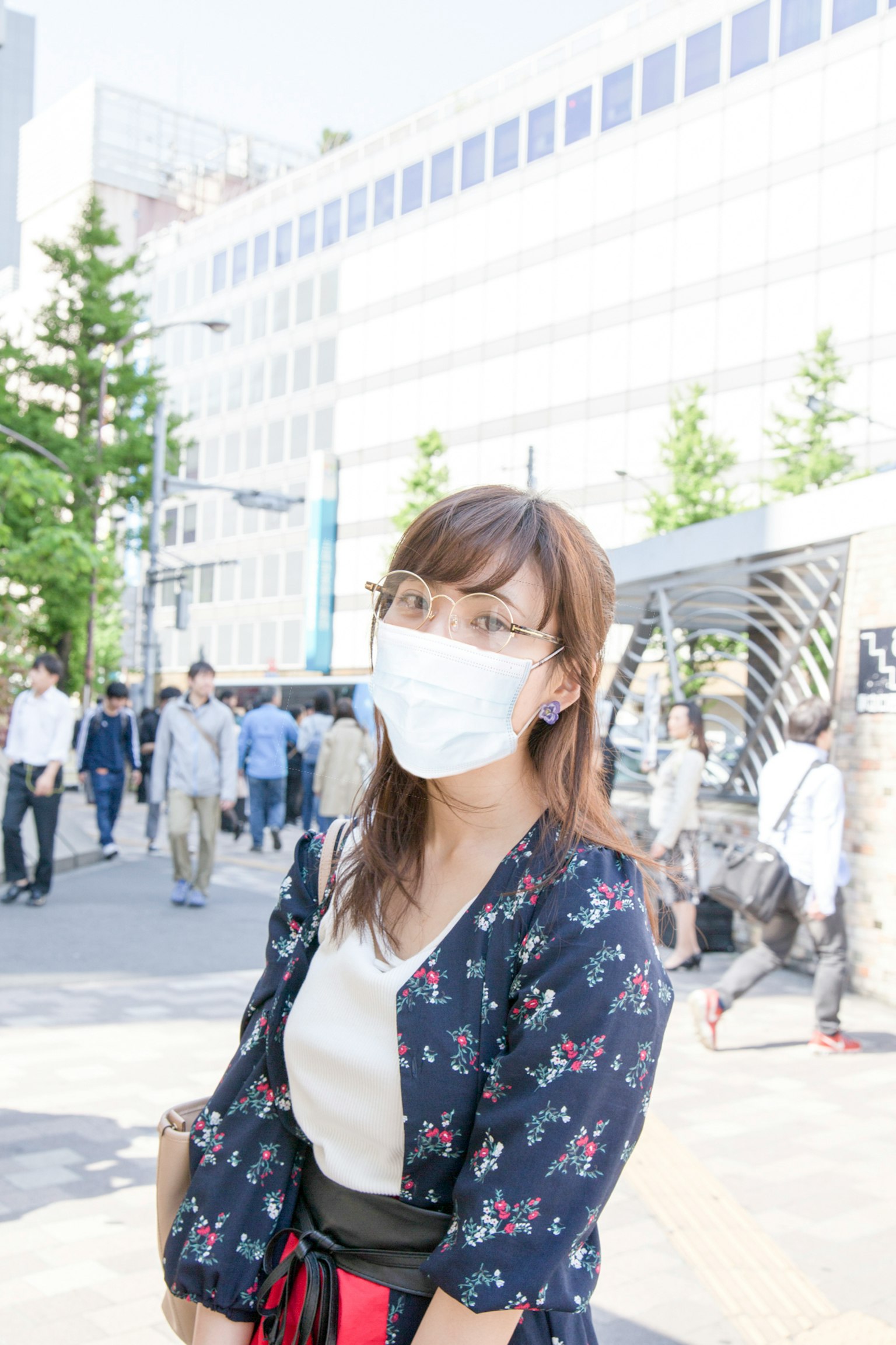 Femme portant un masque et des vêtements fleuris dans une scène de rue en ville