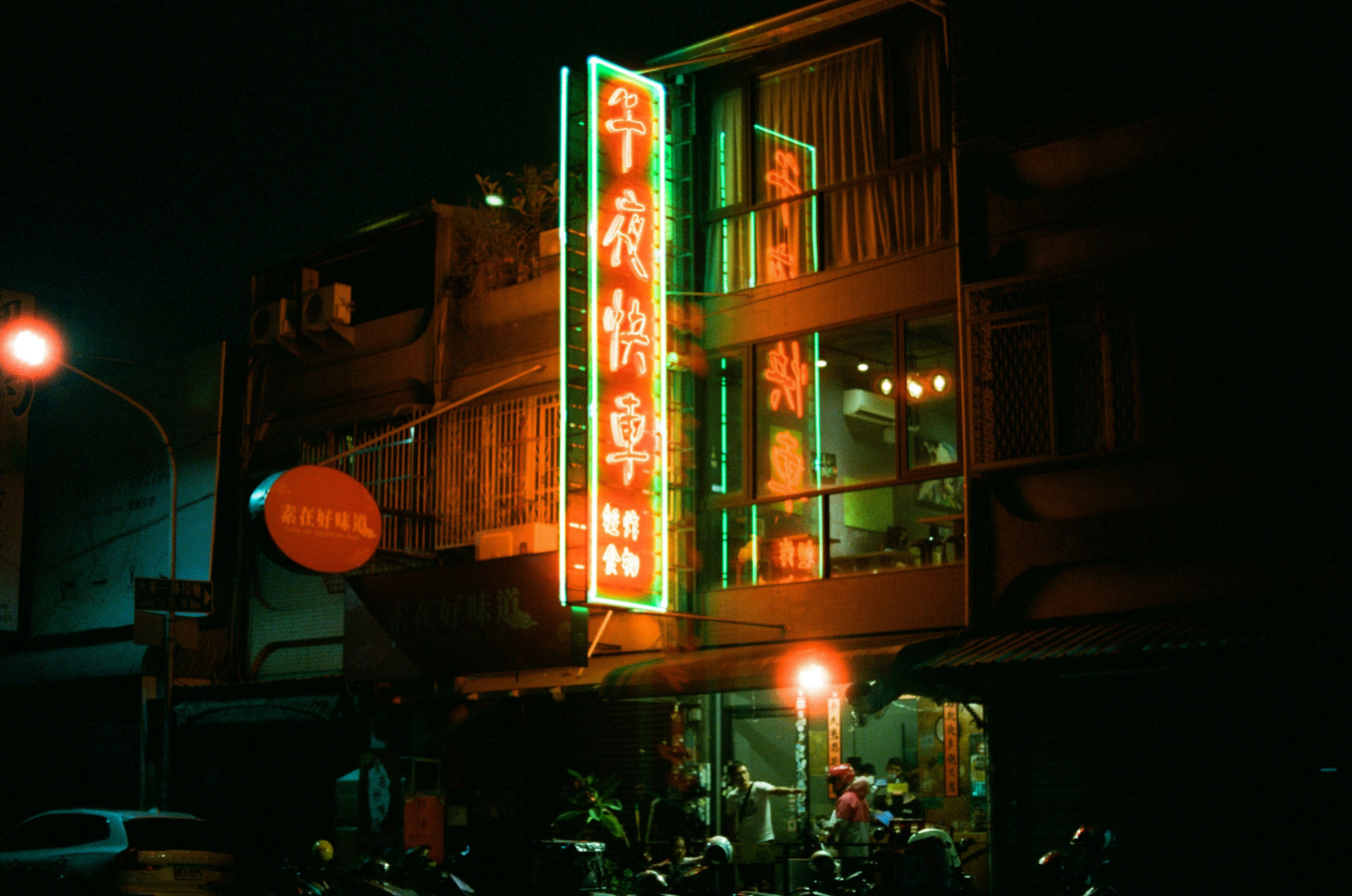 夜の路地にあるネオン看板のある飲食店の外観