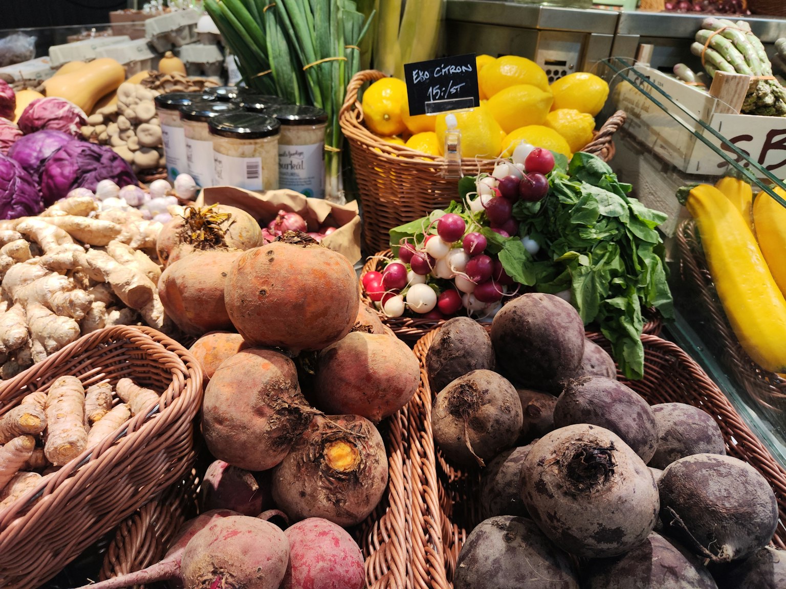 Esposizione vibrante di verdure in un mercato con cesti di ortaggi a radice e verdure a foglia