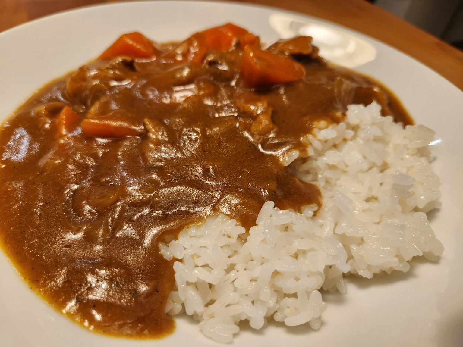 Plato con arroz blanco y salsa de curry decorado con verduras rojas