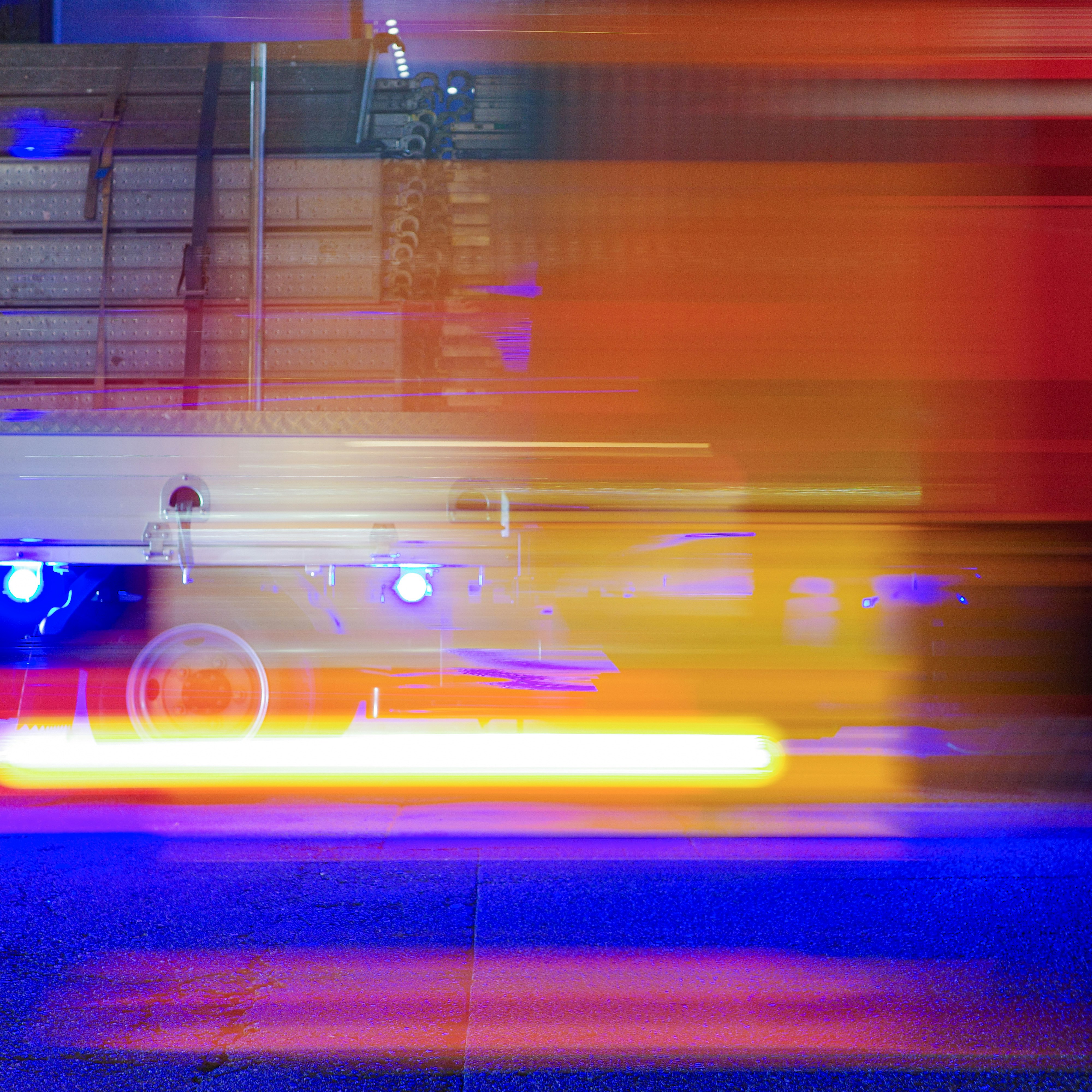 Nächtliche Fahrspuren mit orangefarbenen und violetten Lichtspuren