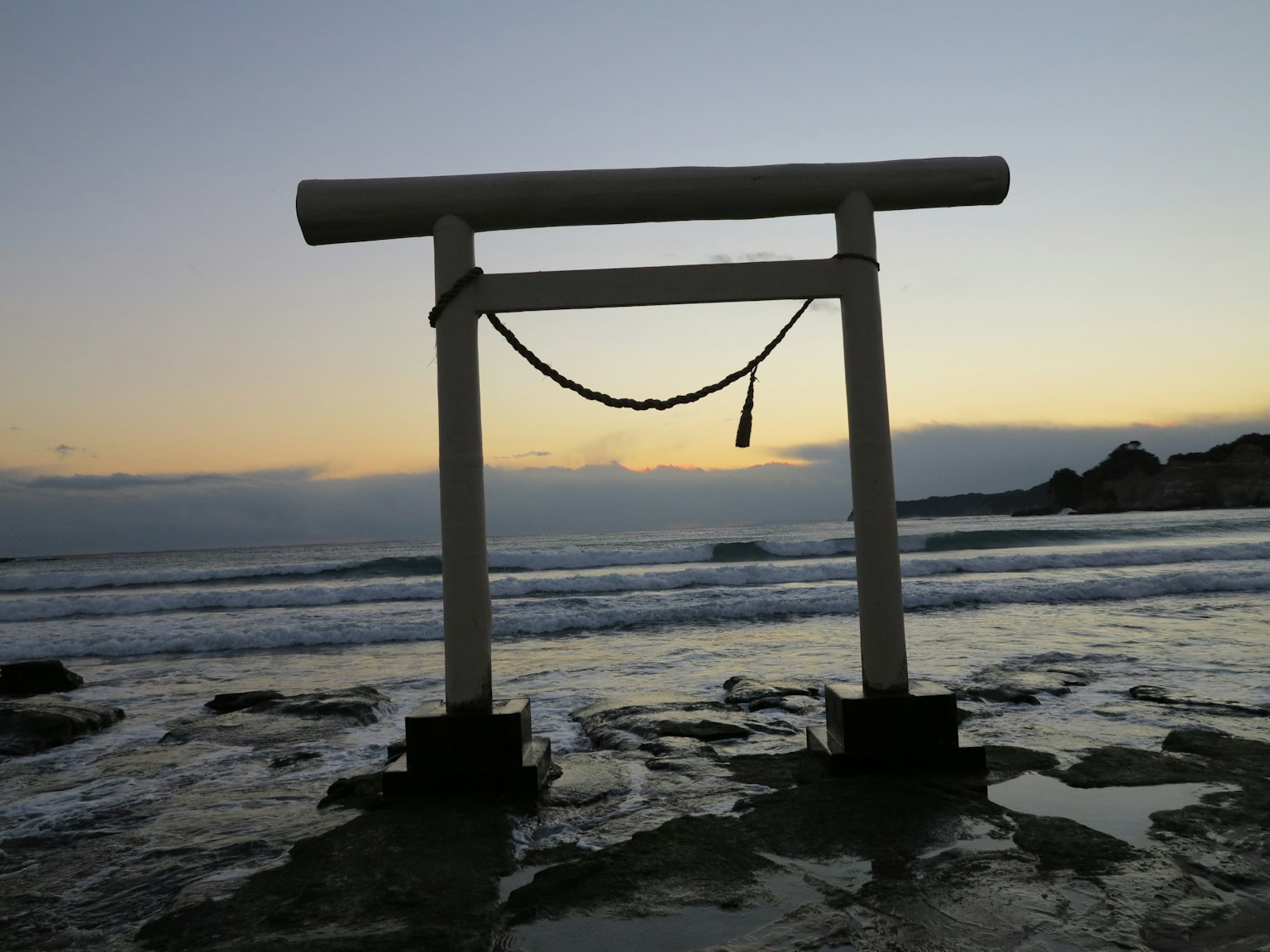 海滩上的白色鸟居和日落