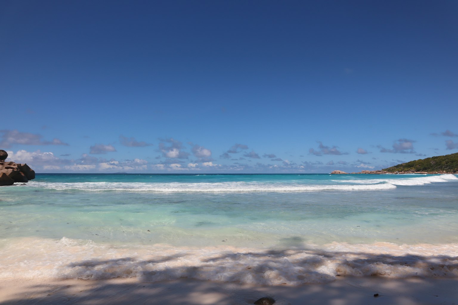Vista de playa escénica con océano azul y arena blanca