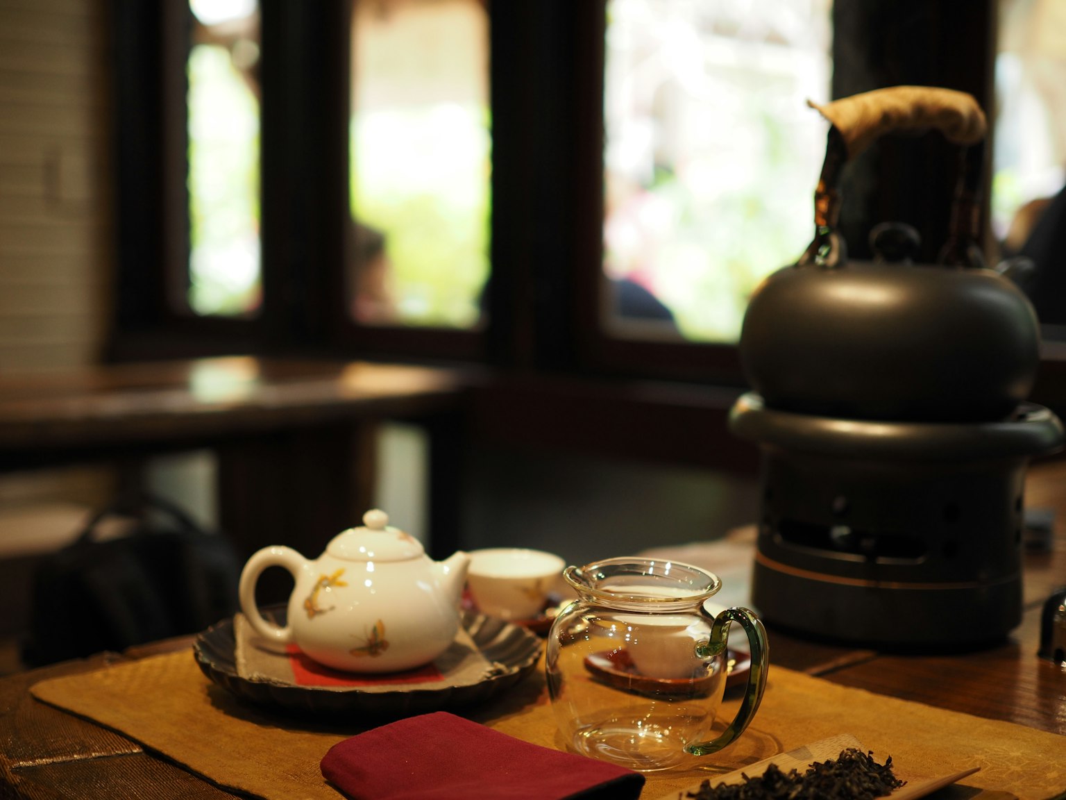 Un sereno conjunto de té con una tetera y un infusor de vidrio sobre una mesa de madera