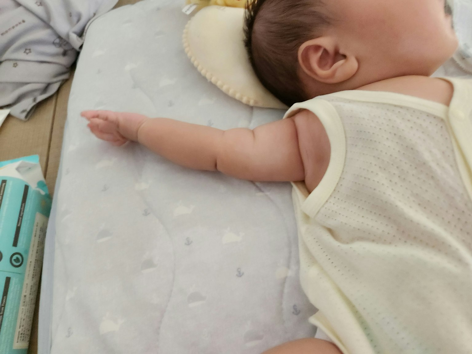 Una vista laterale di un bambino che dorme con un braccio esteso