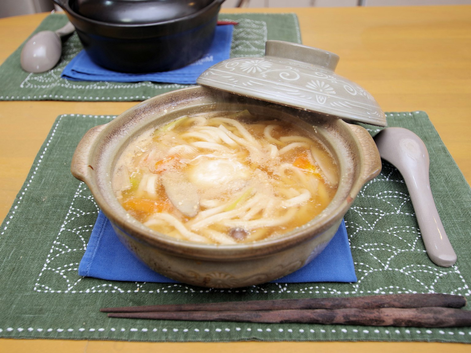 Warme Udon-Nudeln mit Gemüse in einem Tontopf