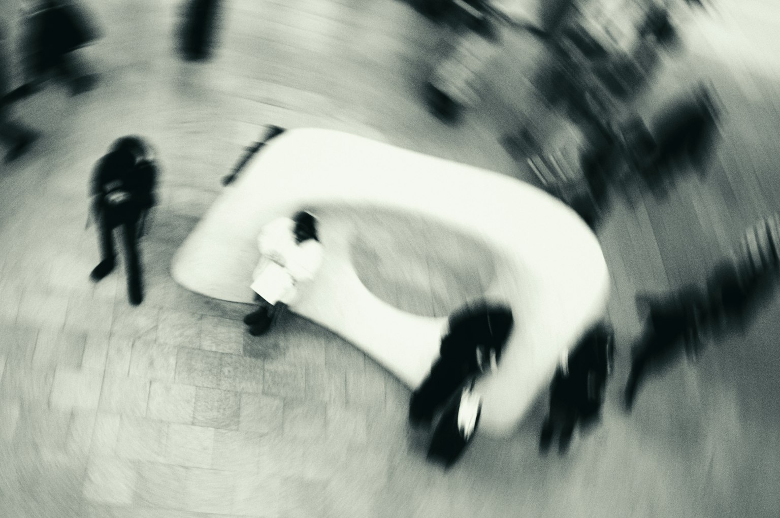 Blurred image of people around a white curved bench
