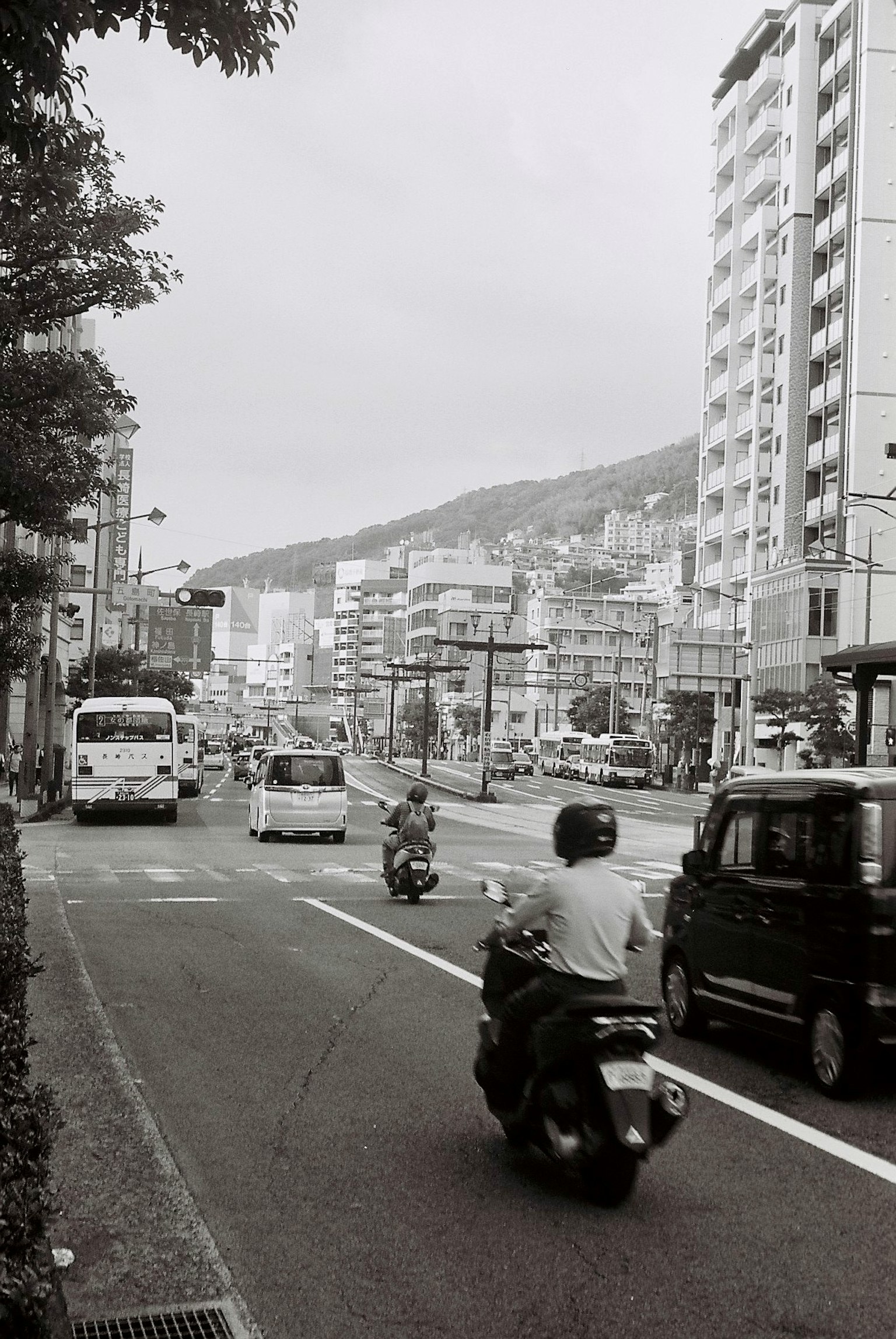 黑白城市景觀，街道上有摩托車和汽車