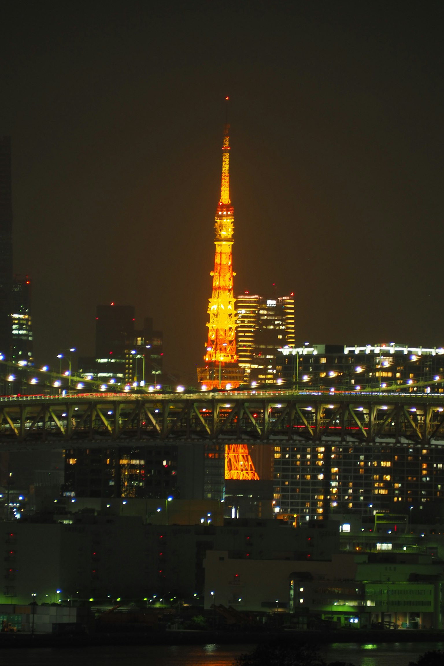도쿄 타워가 밤에 주황색으로 조명된 도시 스카이라인