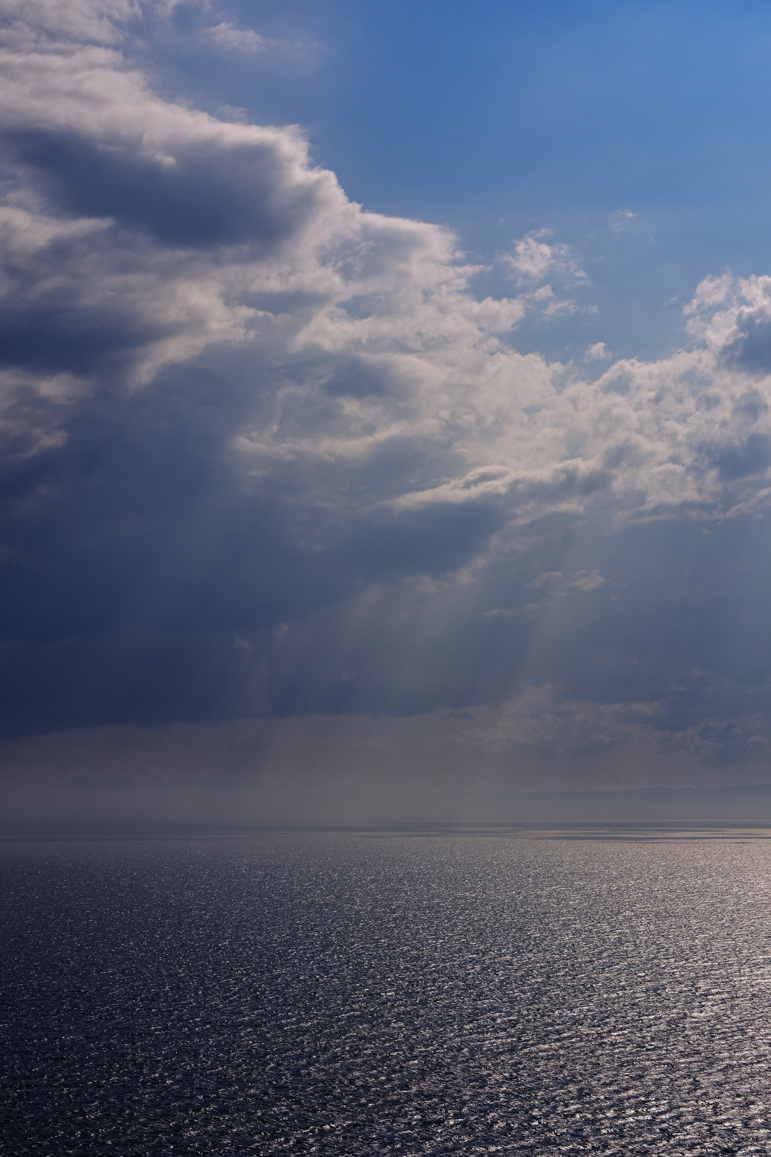 Ciel bleu avec des nuages au-dessus d'un océan scintillant