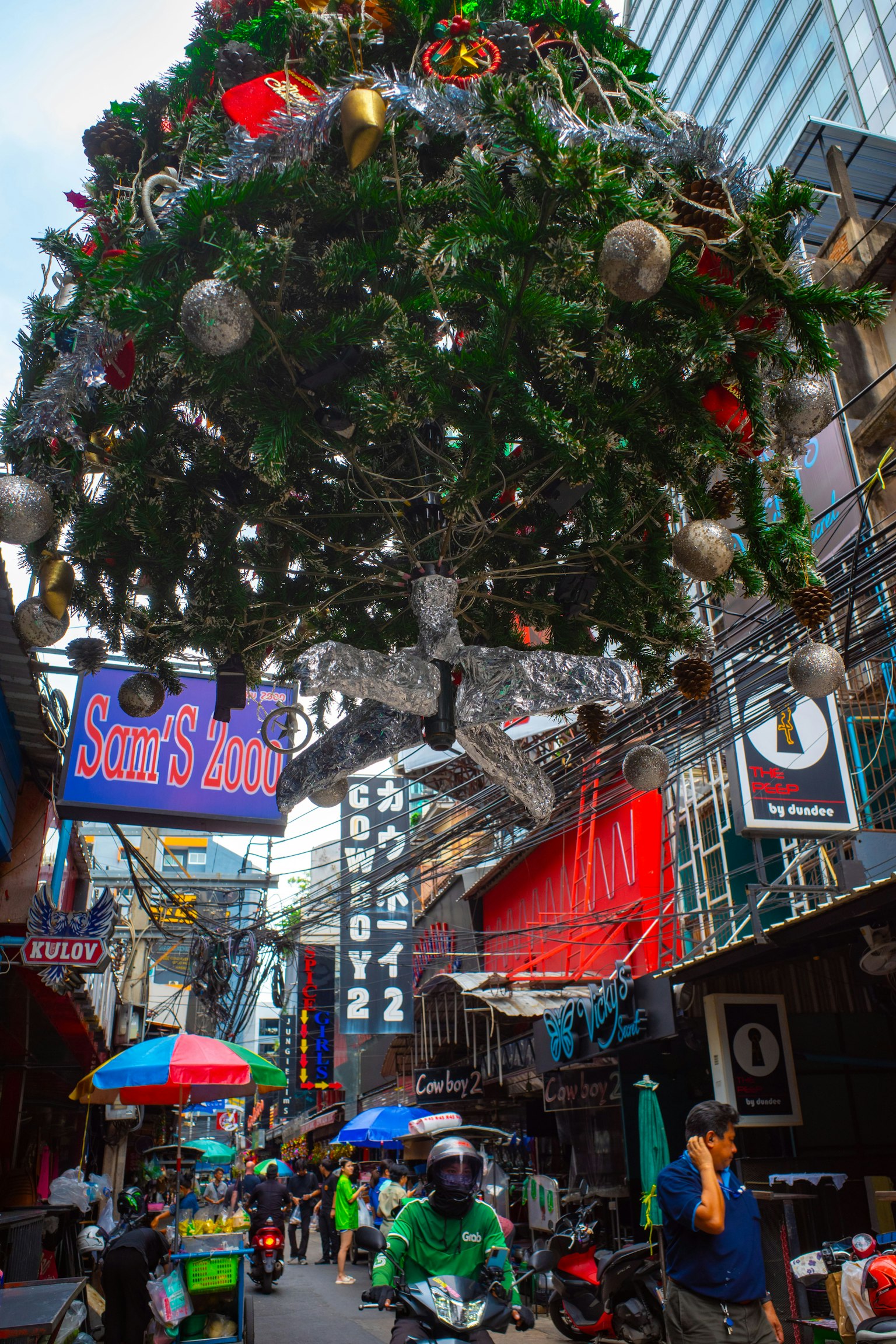 Une scène de rue animée avec un sapin de Noël suspendu au-dessus