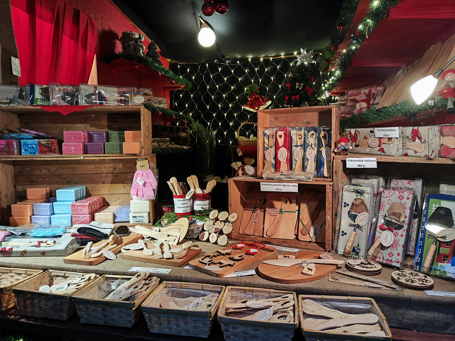 Puesto de mercado navideño que exhibe juguetes de madera y artículos hechos a mano