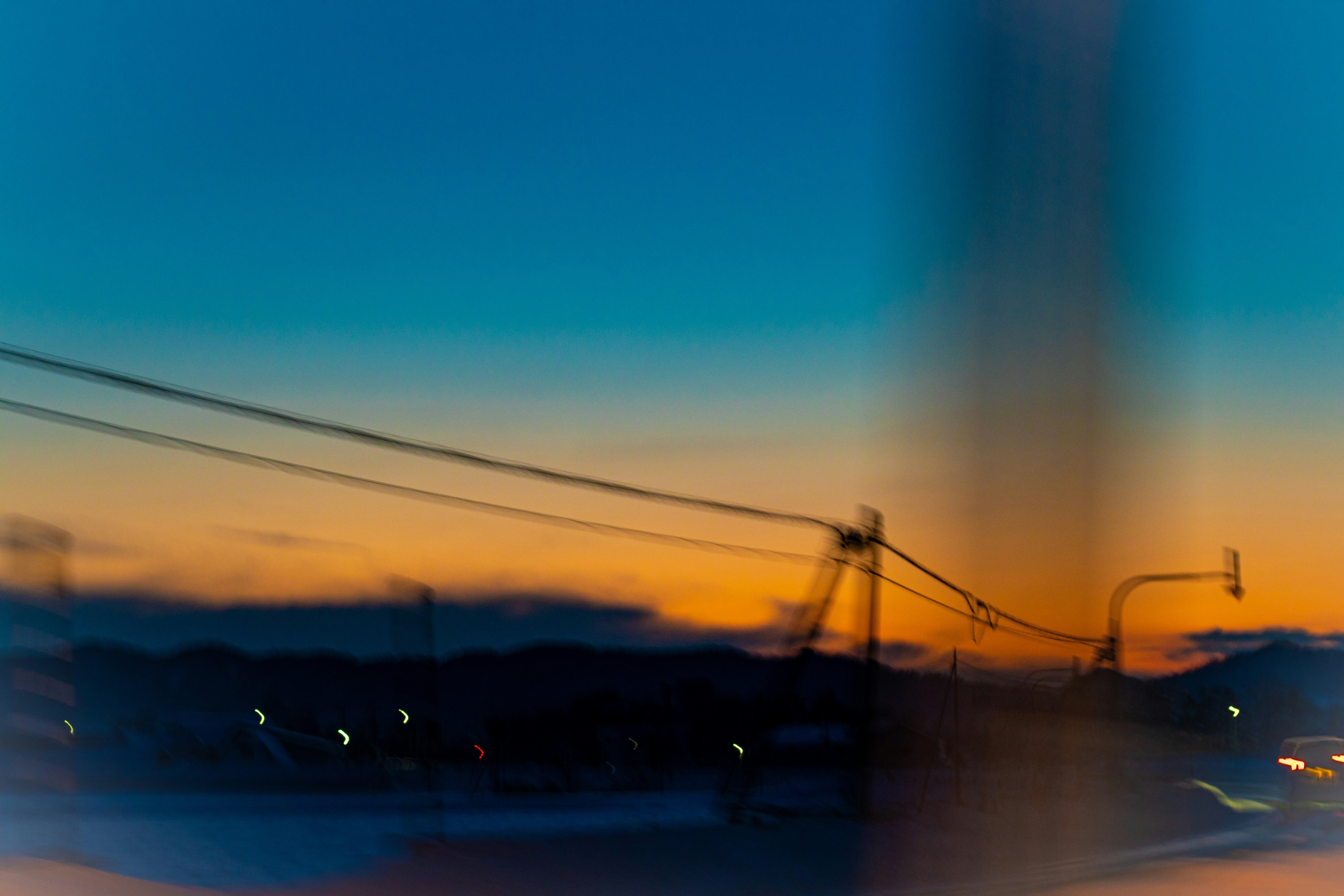 夕暮れの空と街の光がにじむ風景