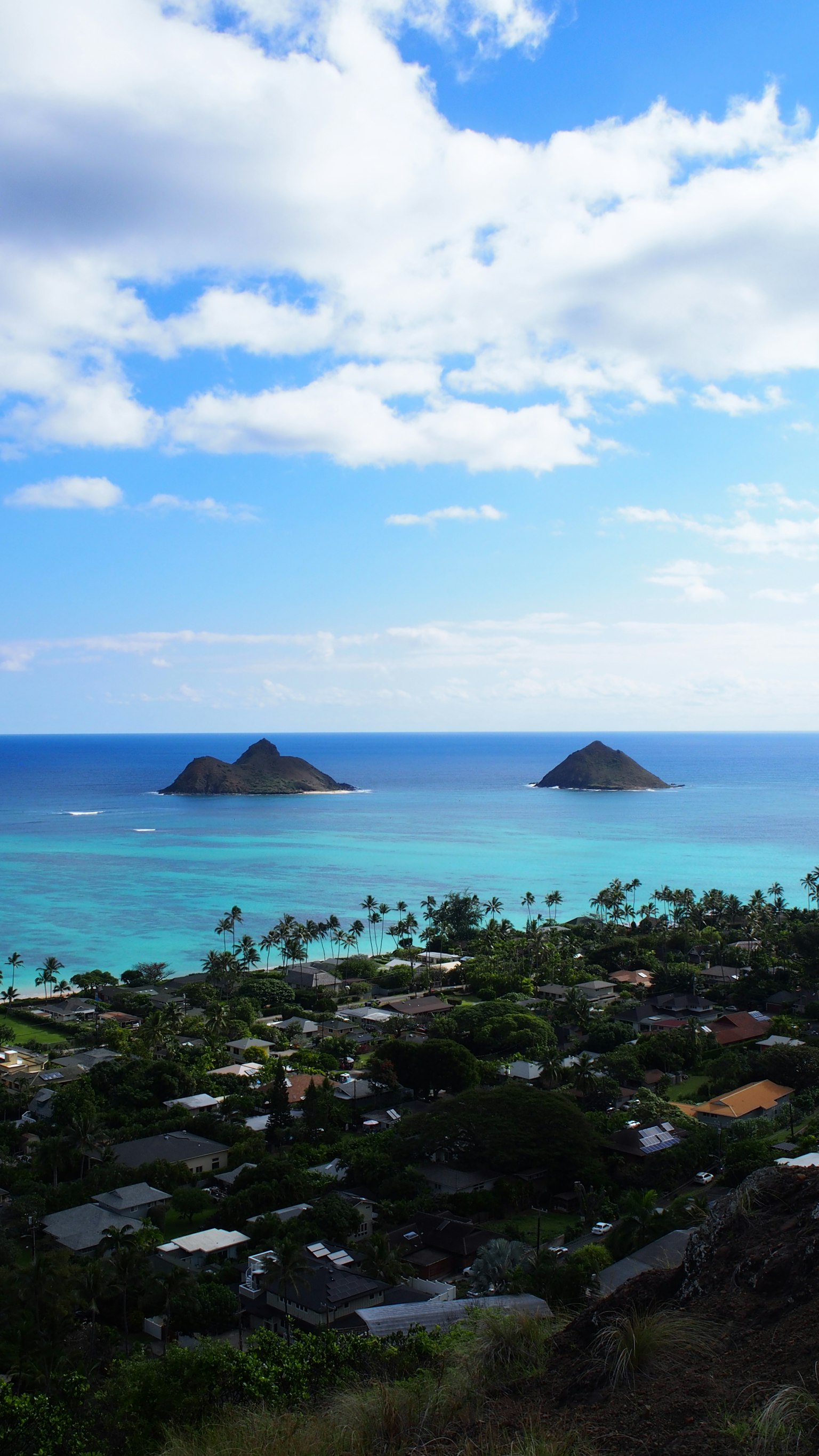 Vue panoramique de l'océan turquoise avec deux îles végétation verte et ciel bleu