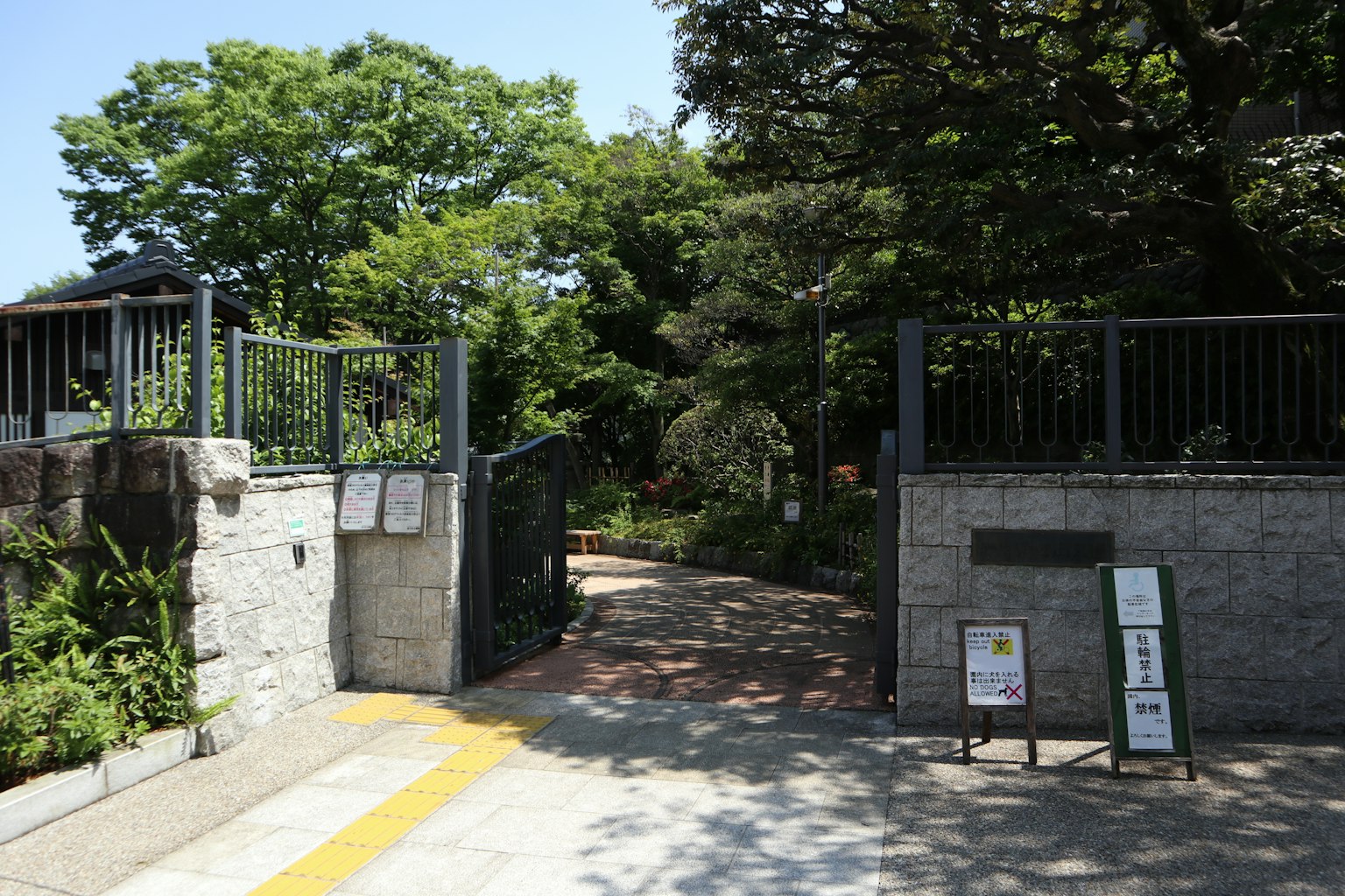 Entrata di un parco verde con alberi e sentieri