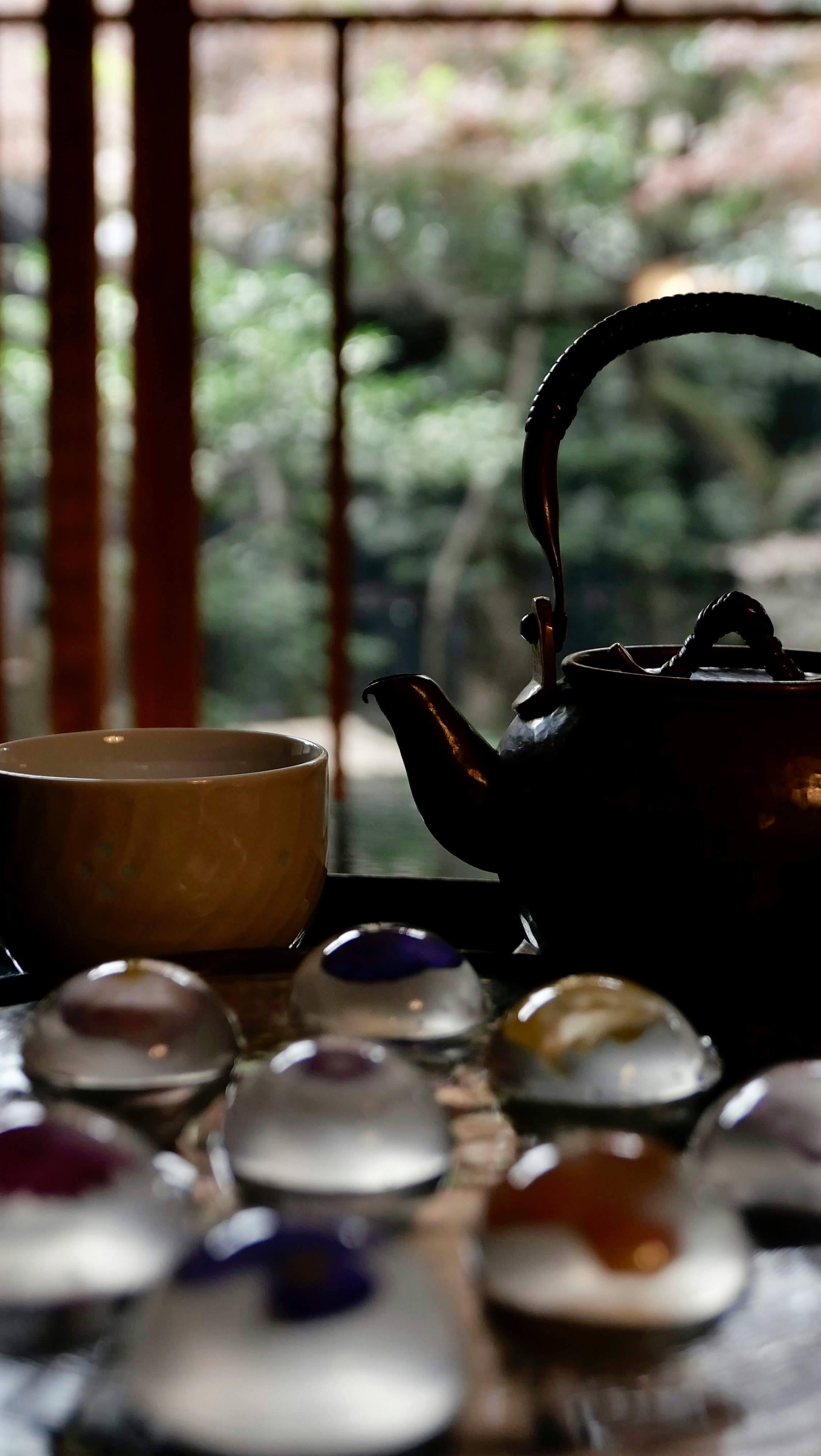 茶器と湯気のある急須、湯呑みのある静かな茶卓