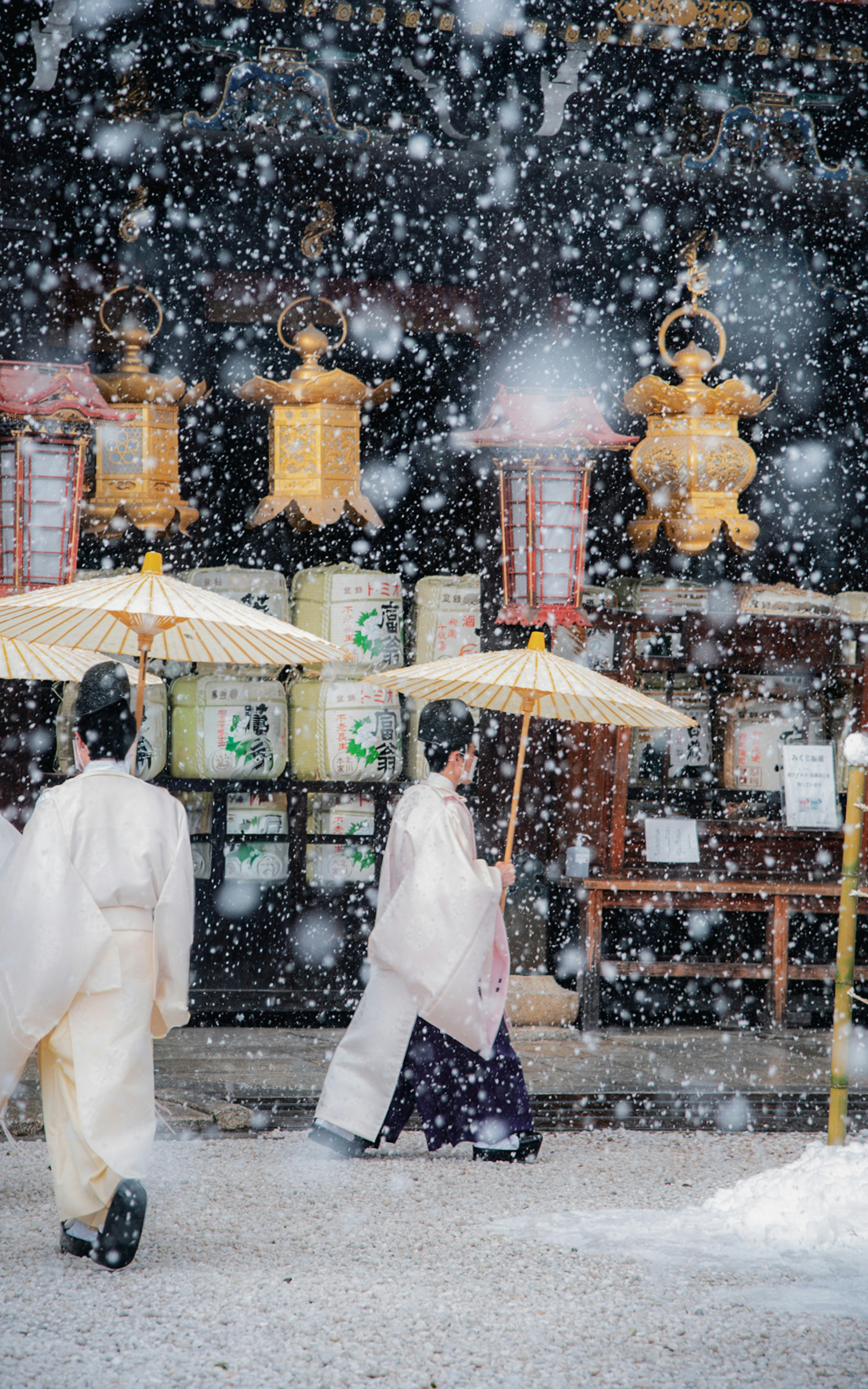 雪の降る京都の屋台通りの提灯と傘のある風景