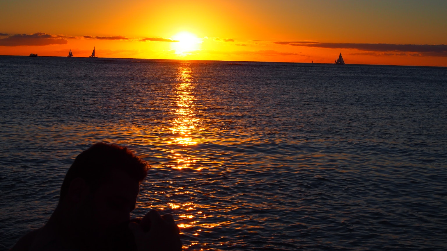 Silhouette di una persona che guarda il mare al tramonto