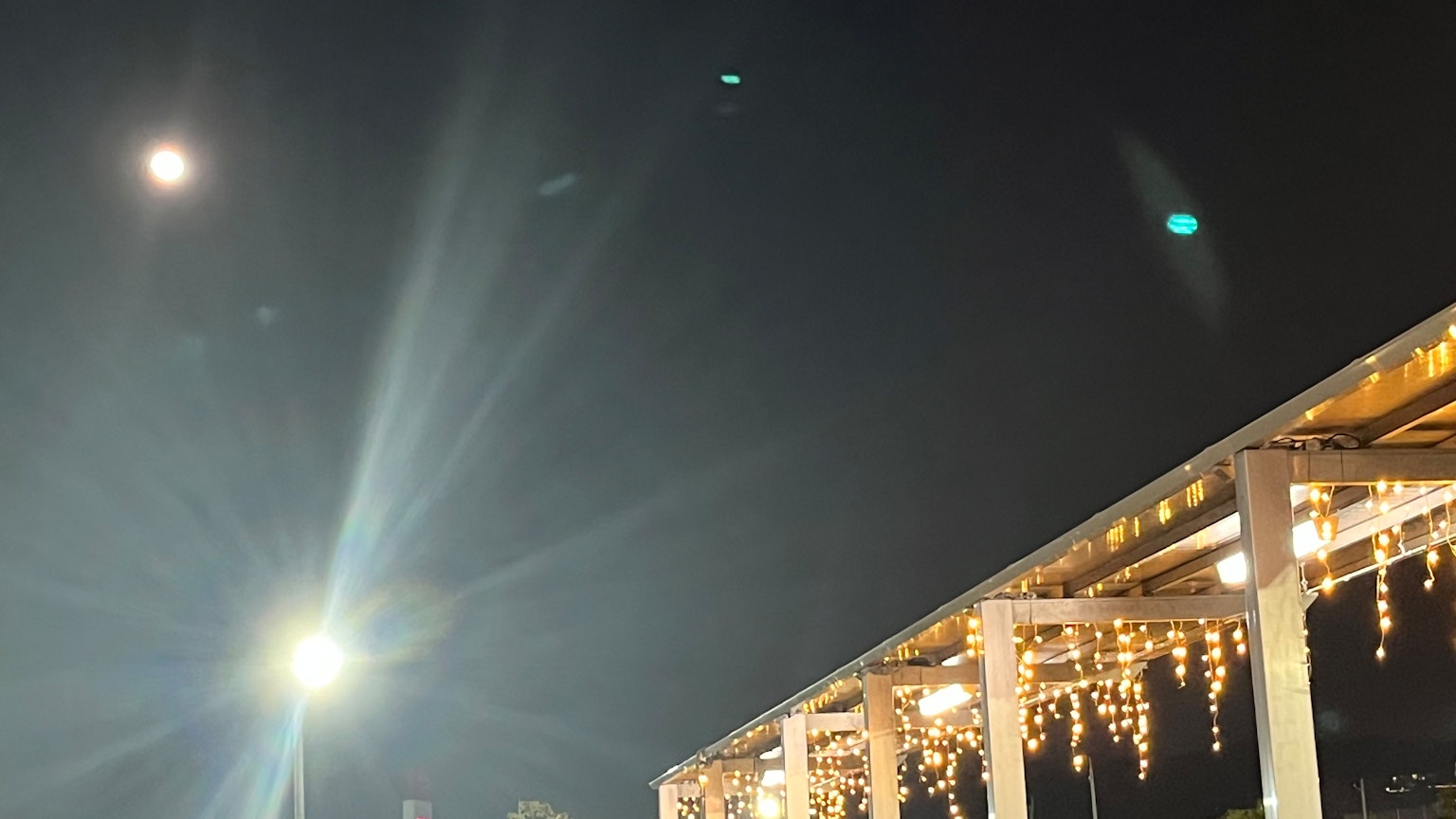 Scène d'un ciel nocturne avec une lune brillante et des étoiles Bâtiment blanc décoré de lumières créant une atmosphère magique
