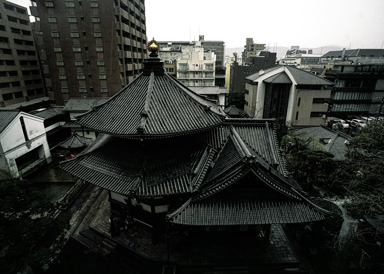 도시 건물 사이에 있는 전통 일본 사원 지붕