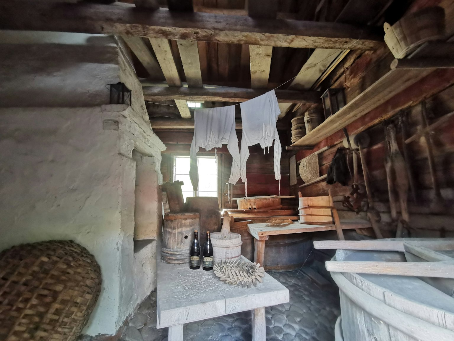 Interno di un'antica fattoria con scaffali e tavolo in legno e luce naturale