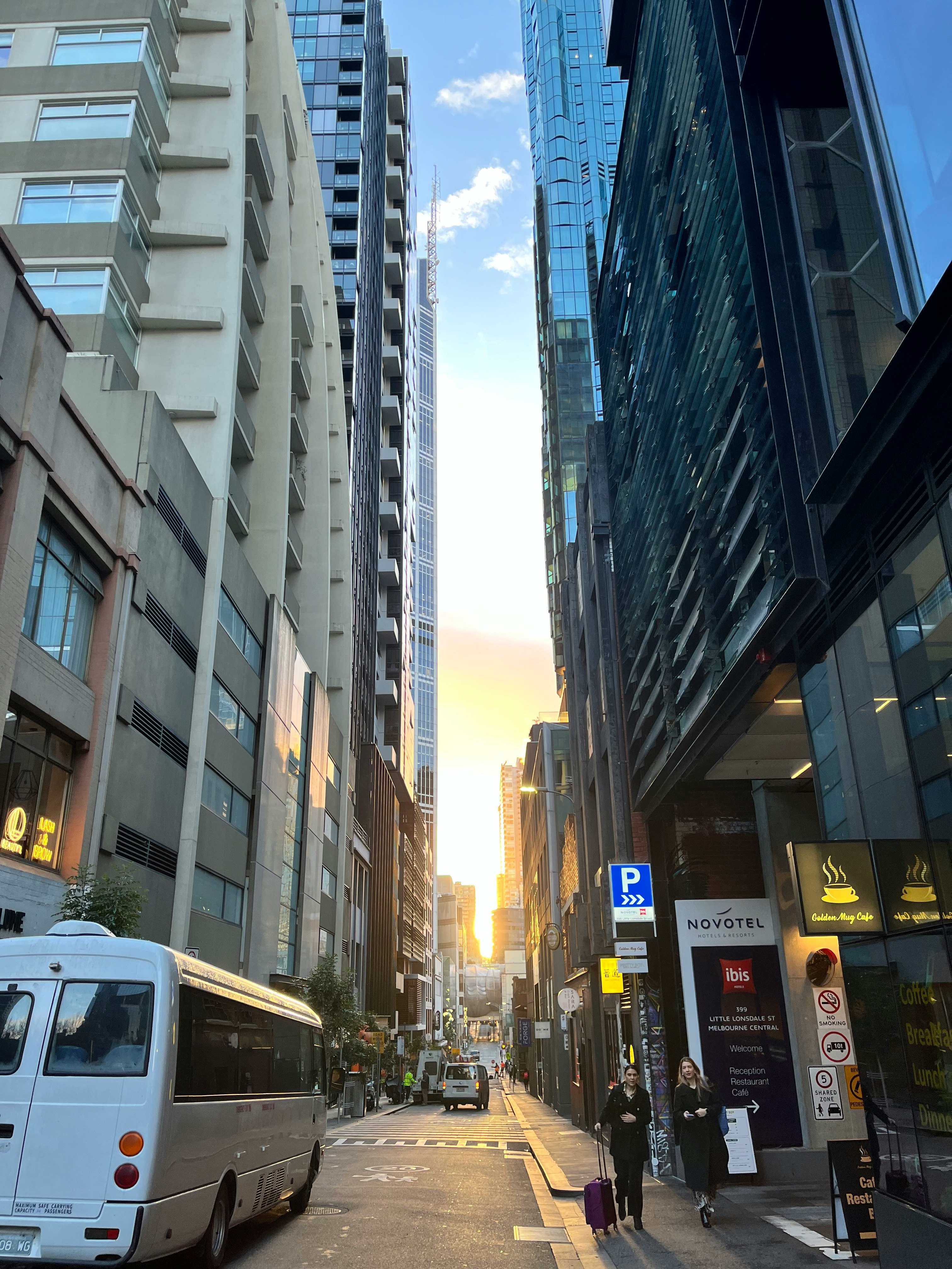 高層ビルに挟まれた都市の通りとバス
