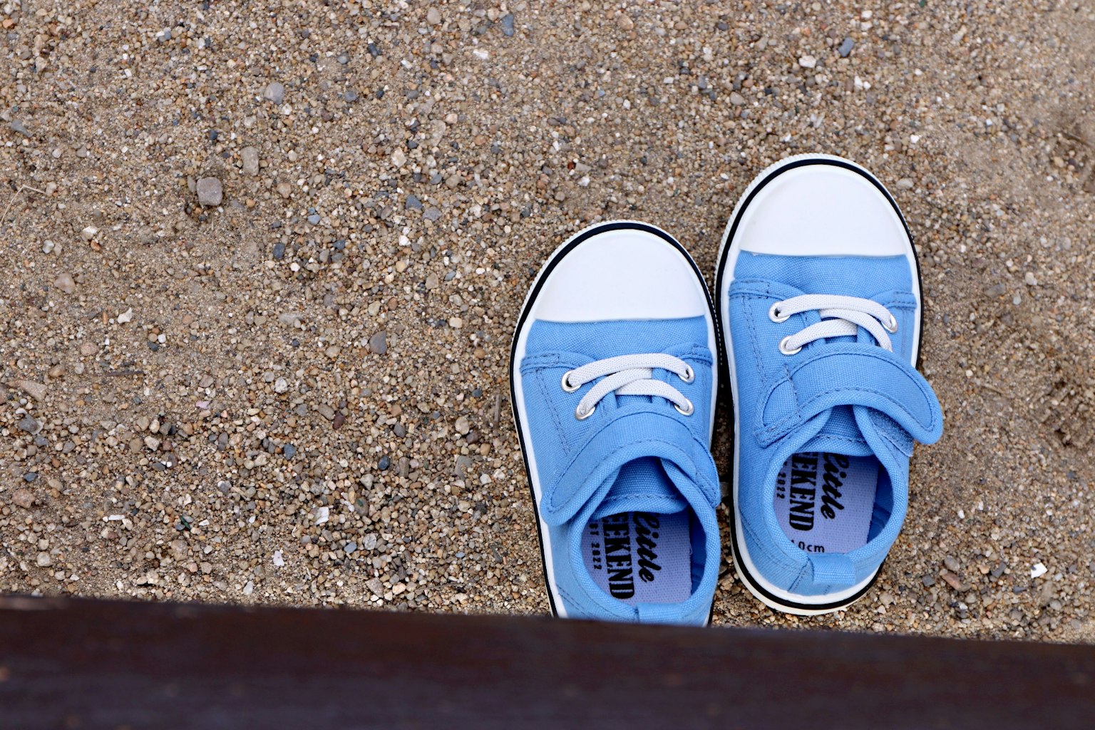 Sneakers blu posati su terreno sabbioso