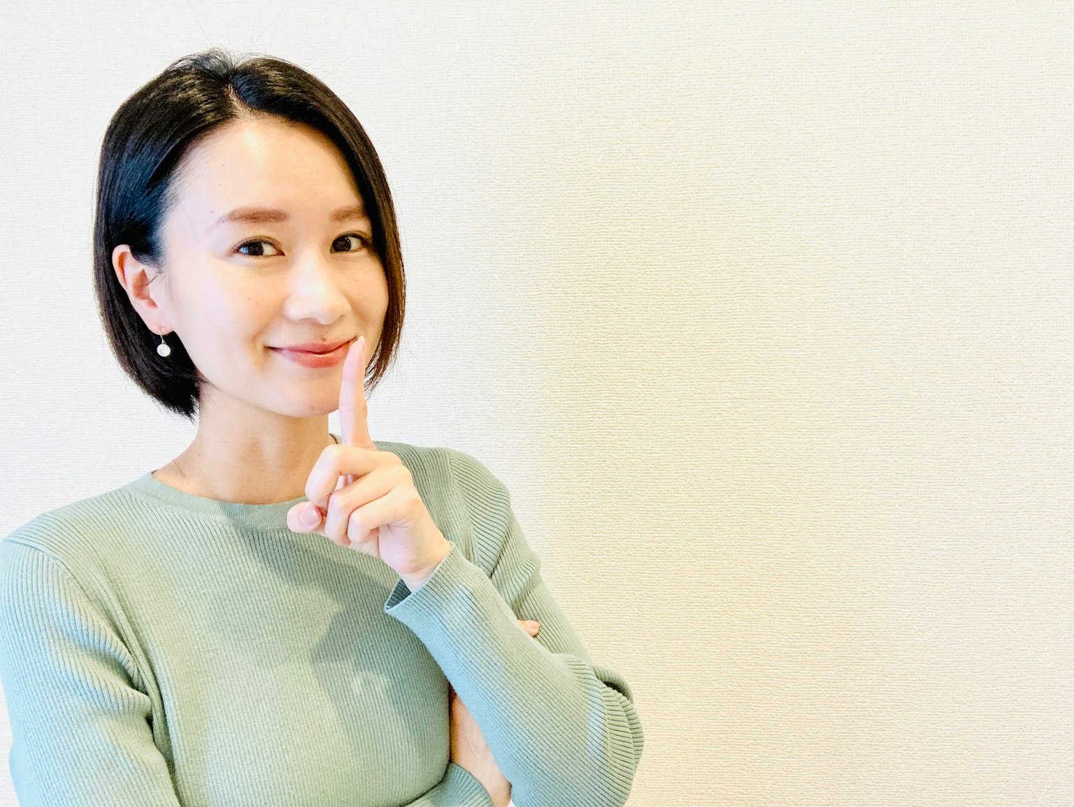 Người phụ nữ trẻ đang ra hiệu im lặng bằng cách đặt ngón tay lên môi