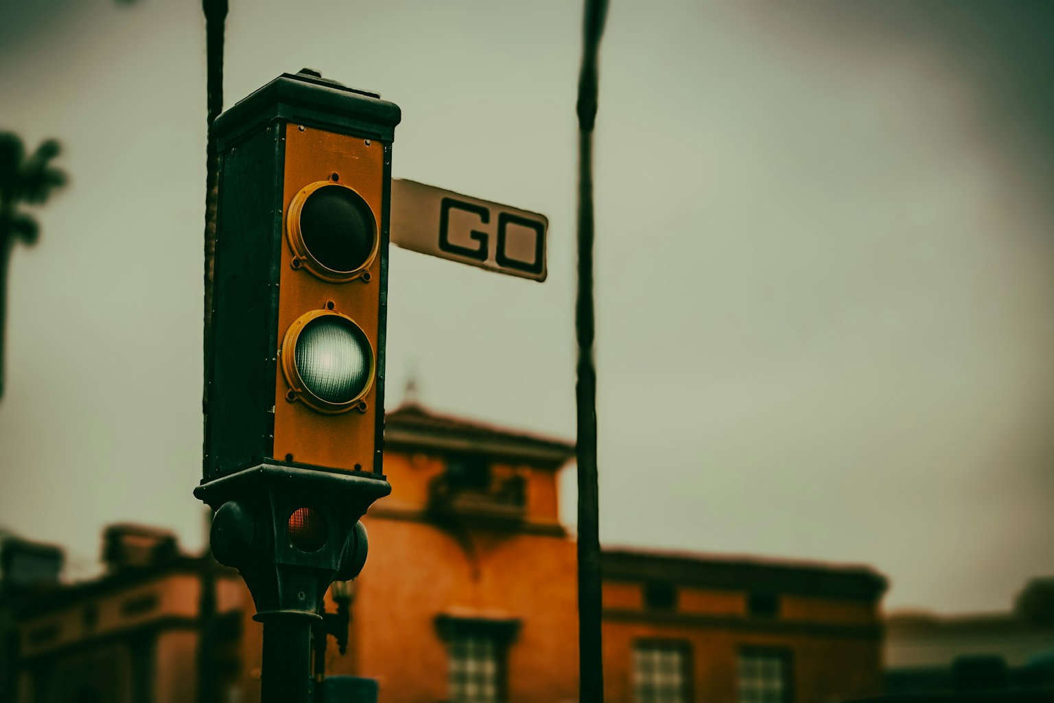 Ampel mit eingeschaltetem grünen Licht und einem Schild mit der Aufschrift GO darüber