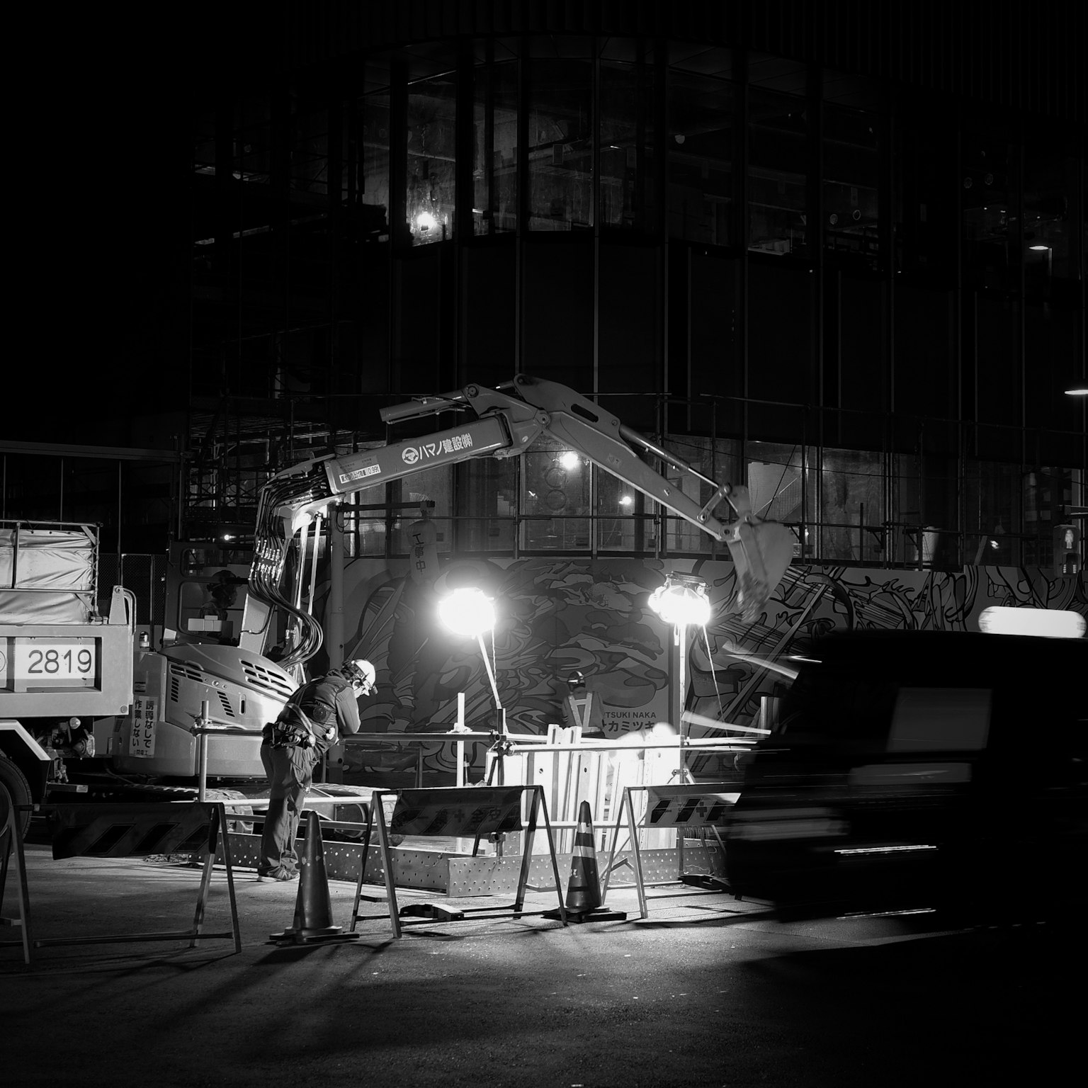 Chantier de construction la nuit avec des ouvriers et des machines éclairées