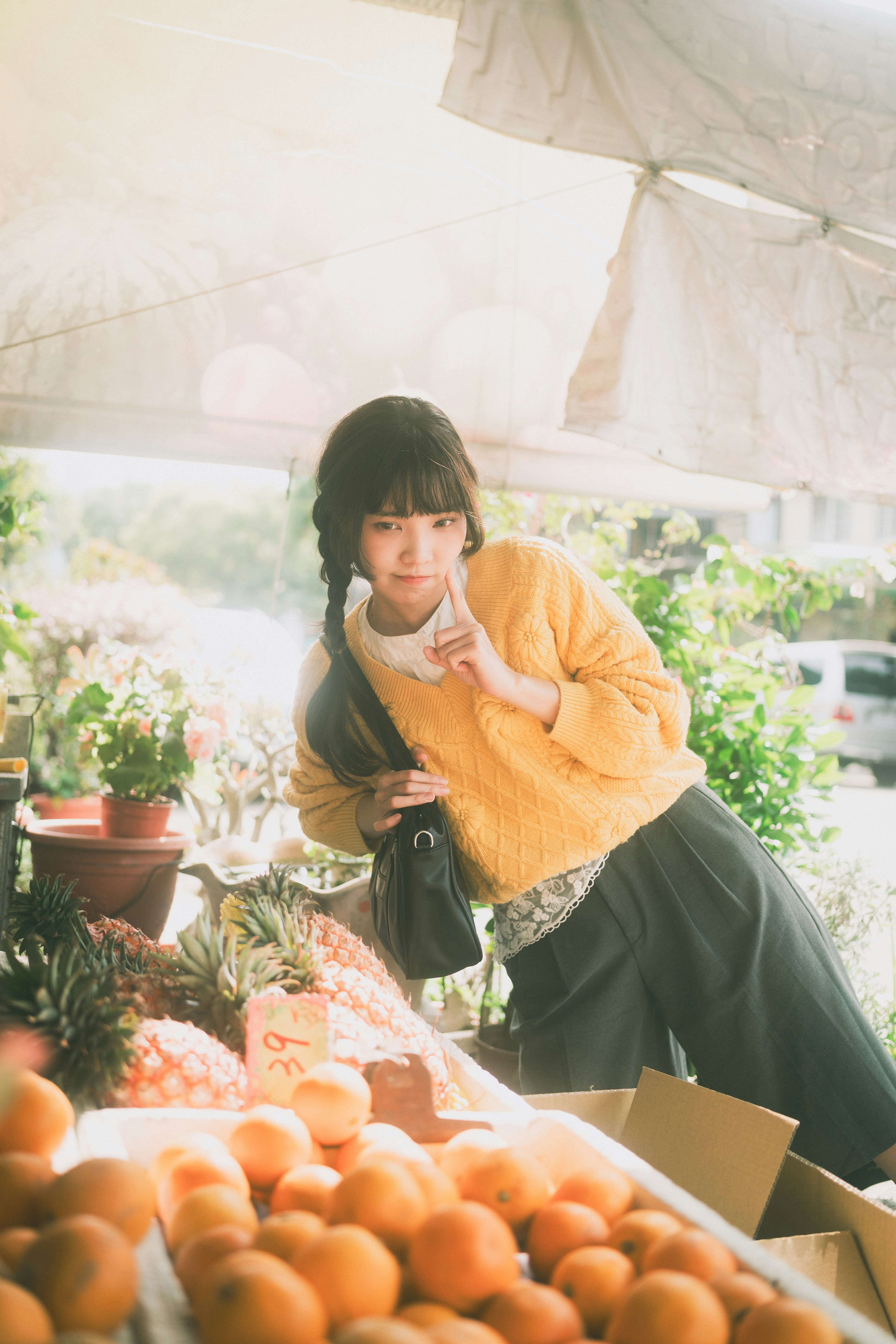 オレンジの入った箱の前で微笑む元気な女の子