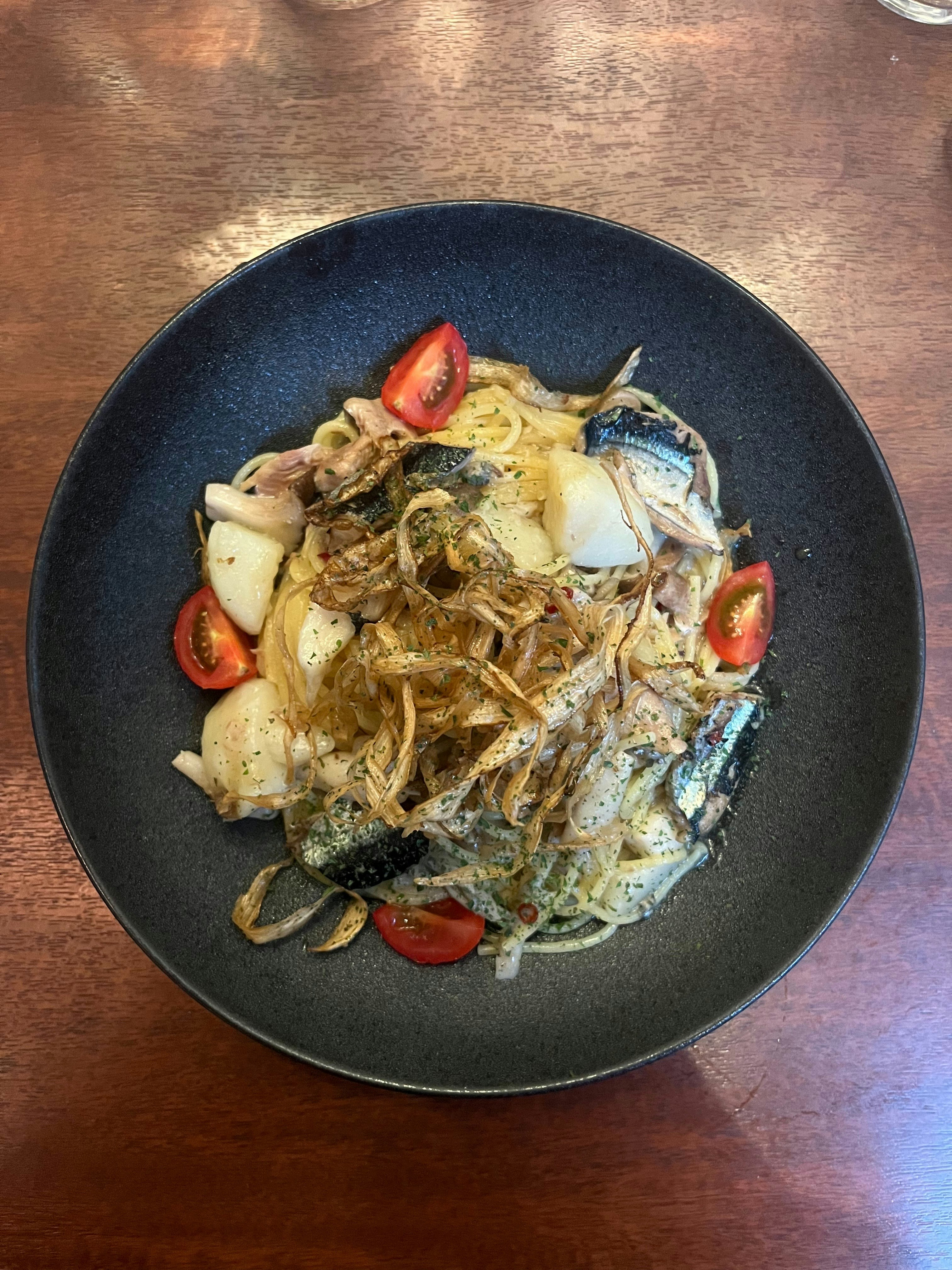 木目のテーブル上の魚介パスタ