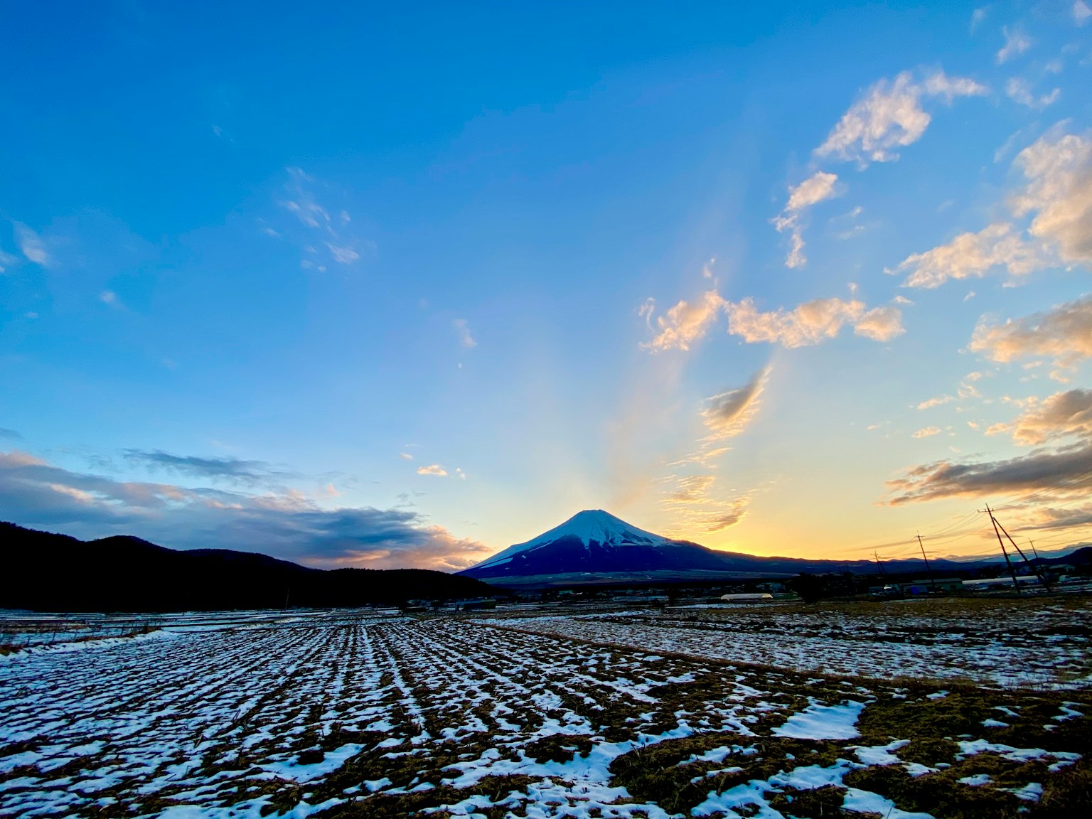 富士山在日落時的美麗景色，雪覆蓋的田野