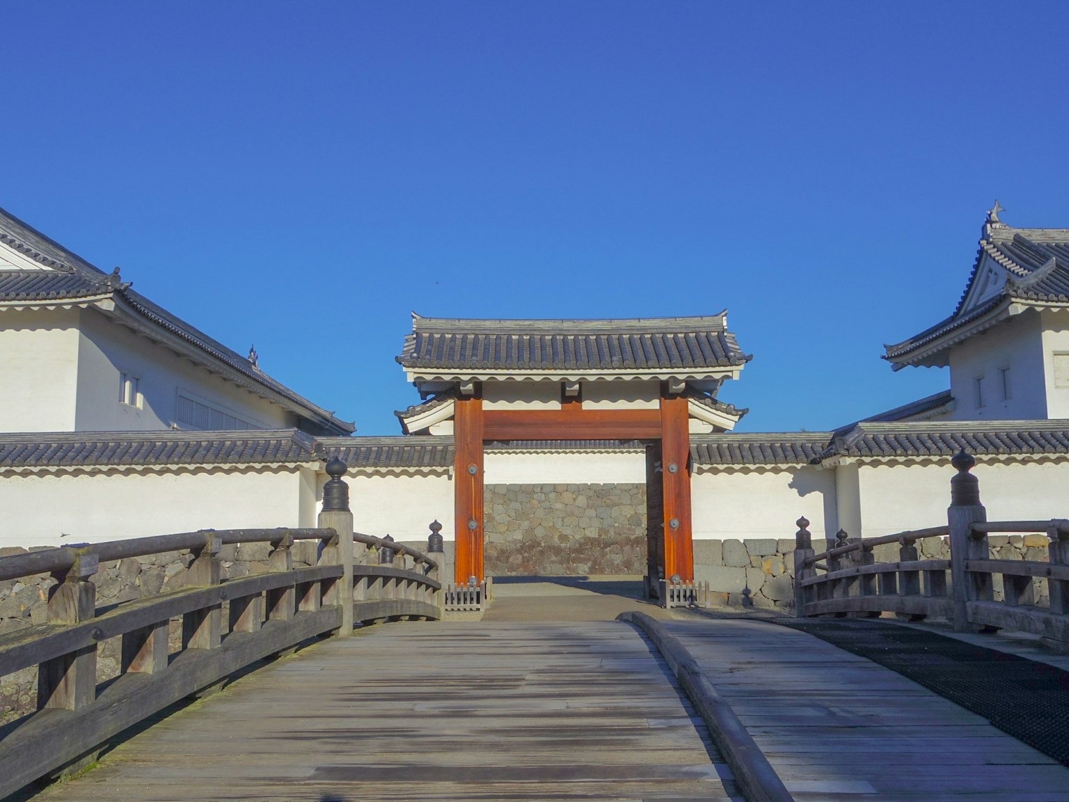 Blick auf ein traditionelles japanisches Tor von einer Brücke aus