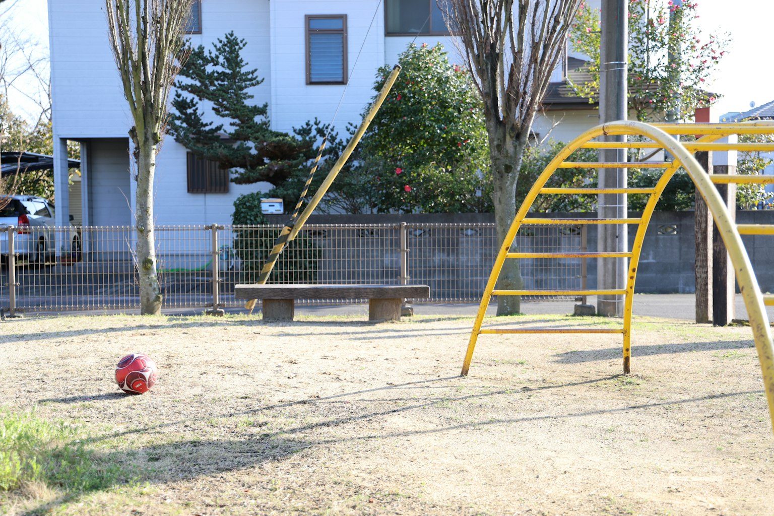 Scena di un parco con attrezzature per bambini con un'altalena gialla e una sabbiera