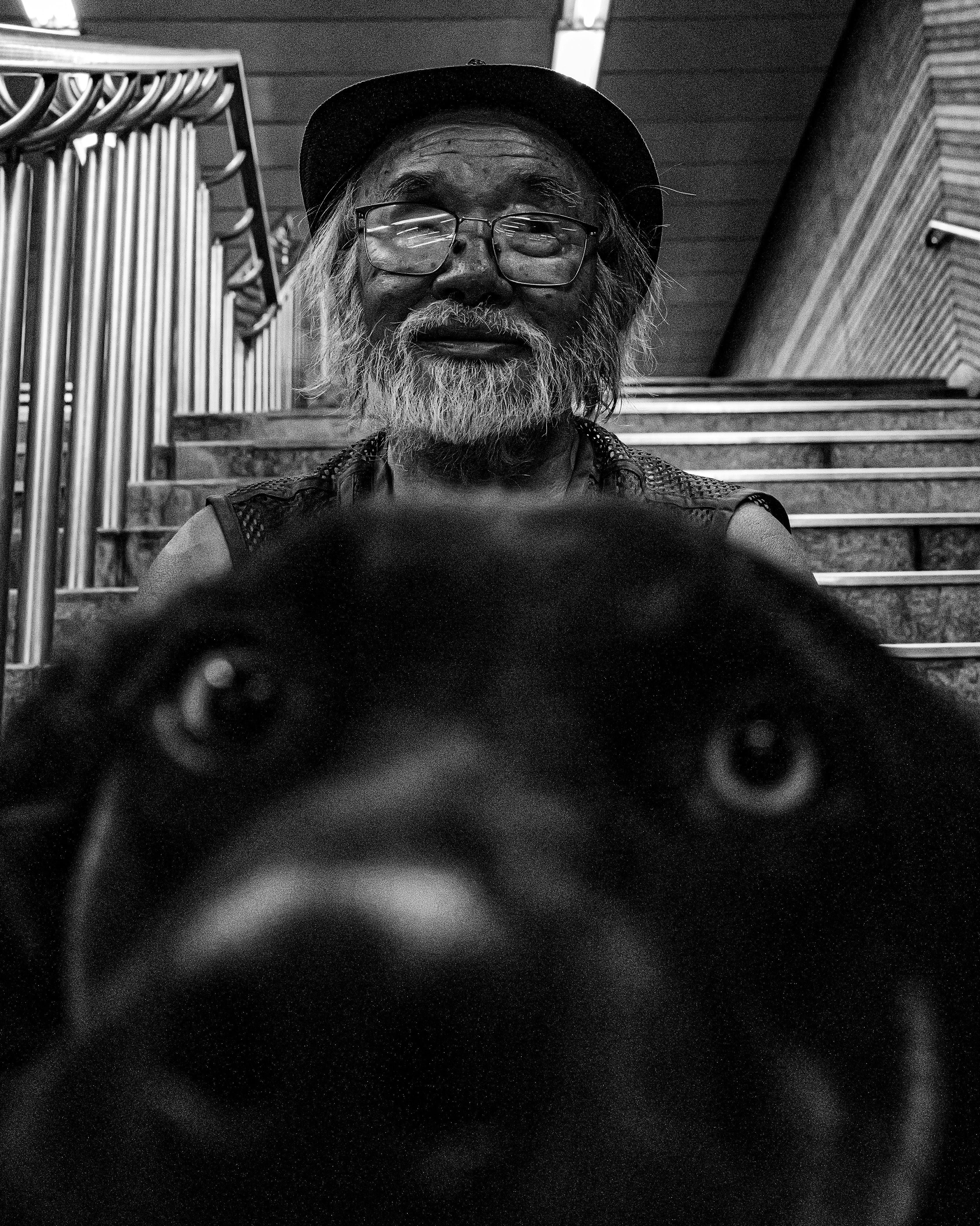 A homeless man and his dog sitting together on the stairs at Seoul Station