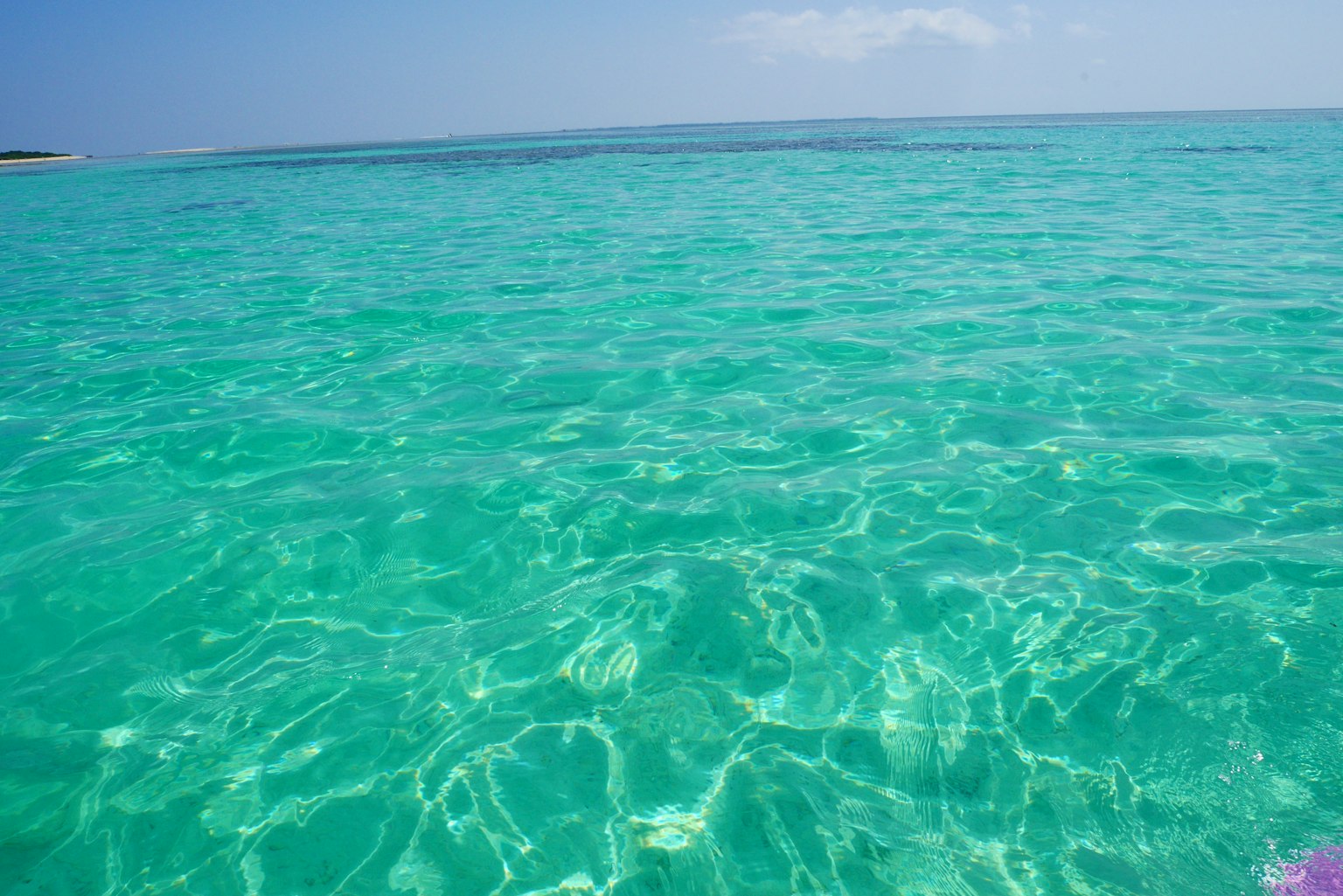 Bề mặt nước biển màu ngọc lam trong xanh dưới bầu trời xanh