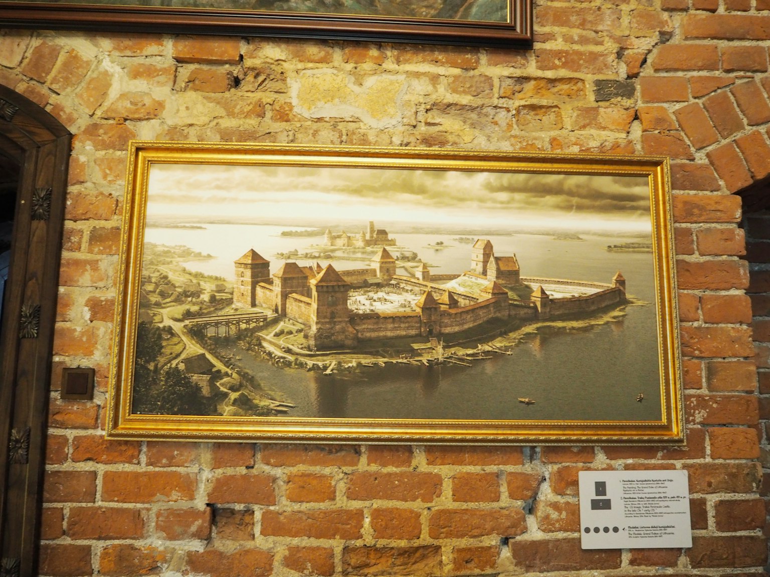 Pintura de una fortaleza exhibida en una pared de ladrillos