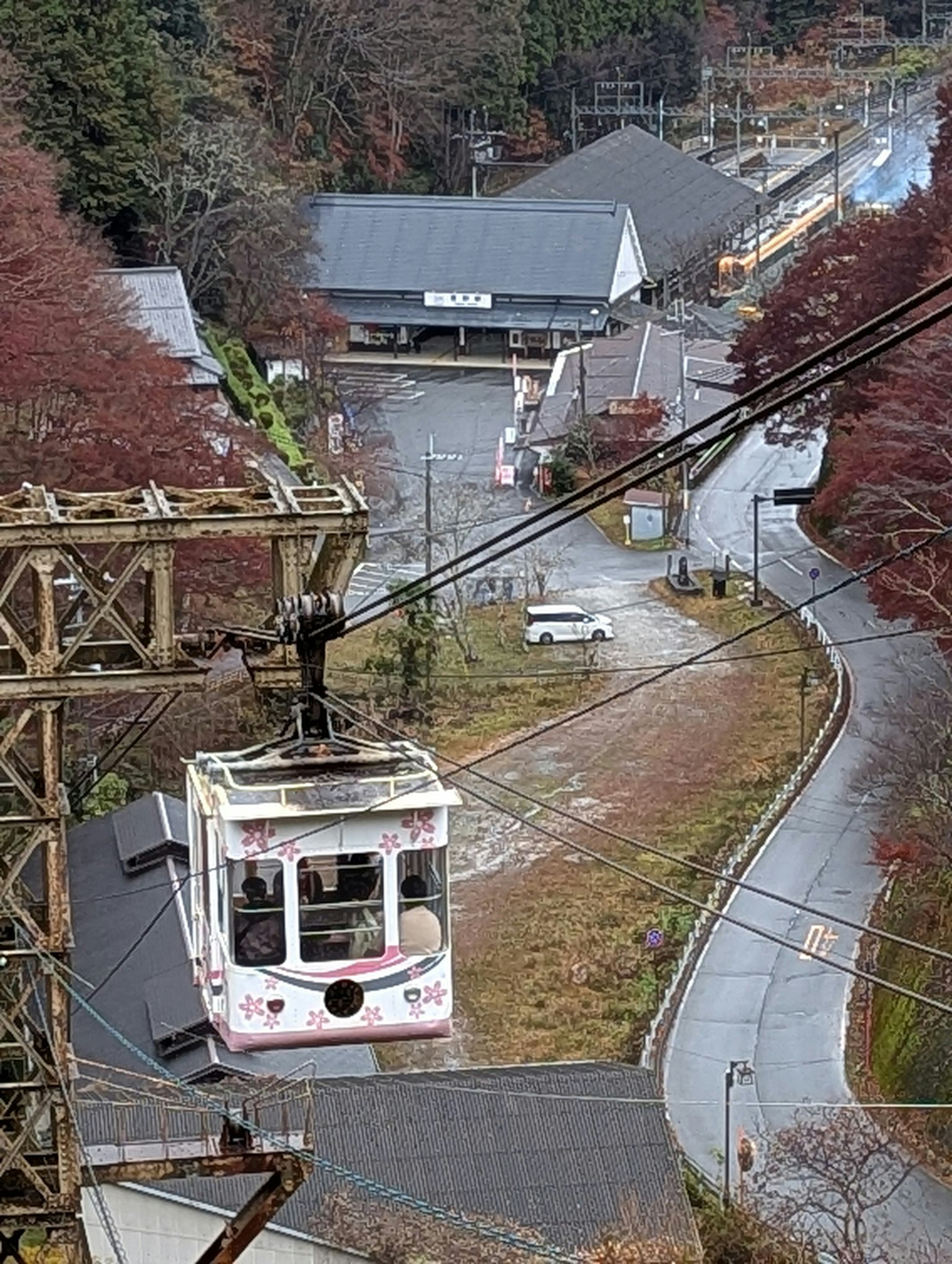 Un teleférico subiendo por una ladera montañosa rodeada de vibrante follaje otoñal