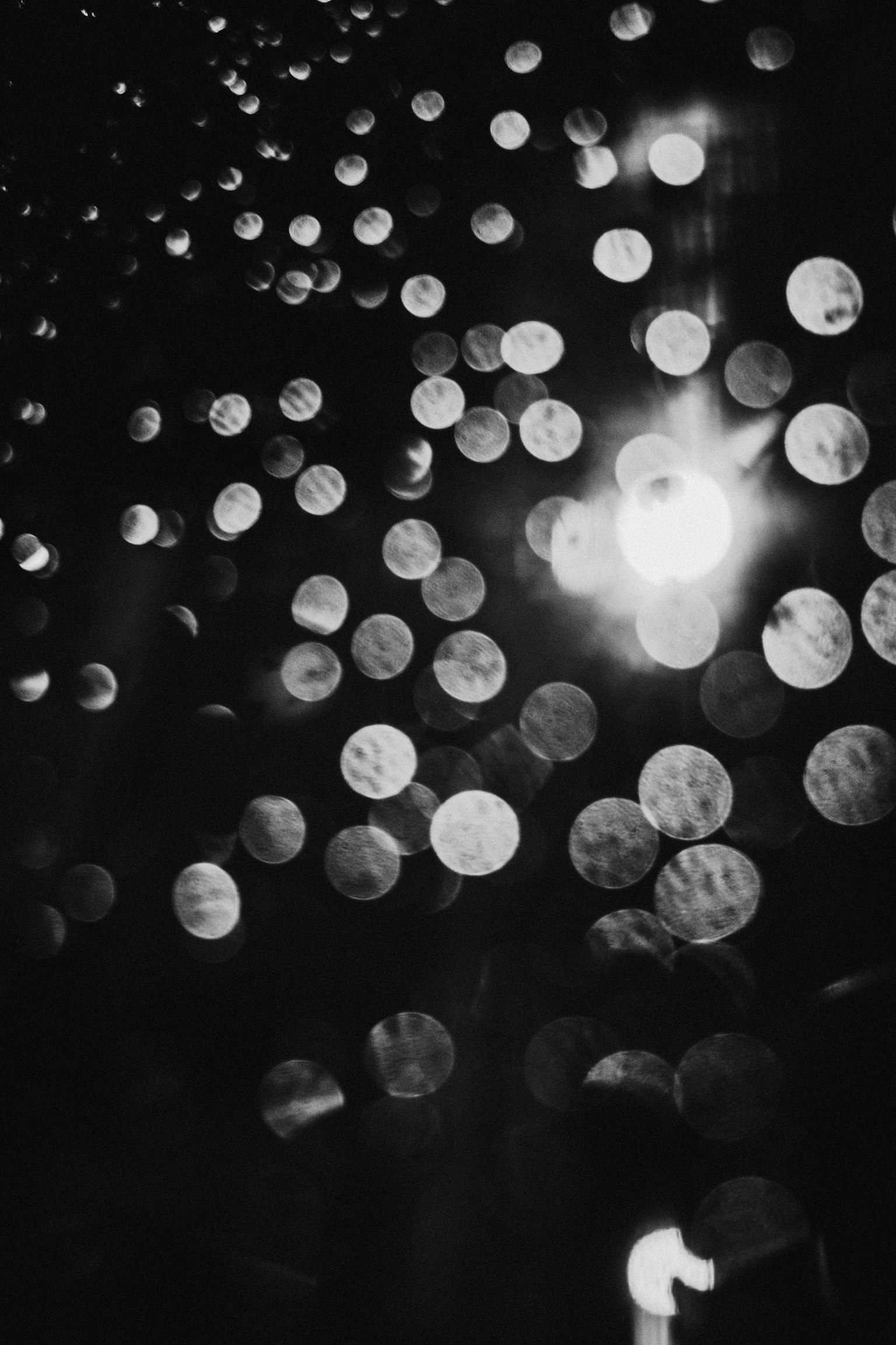 Imagen abstracta de puntos de luz borrosos dispersos sobre un fondo blanco y negro
