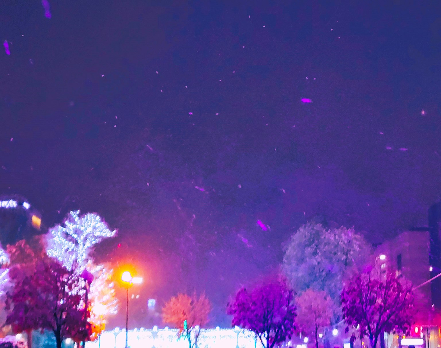 夜景中紫色燈光與飄落雪花