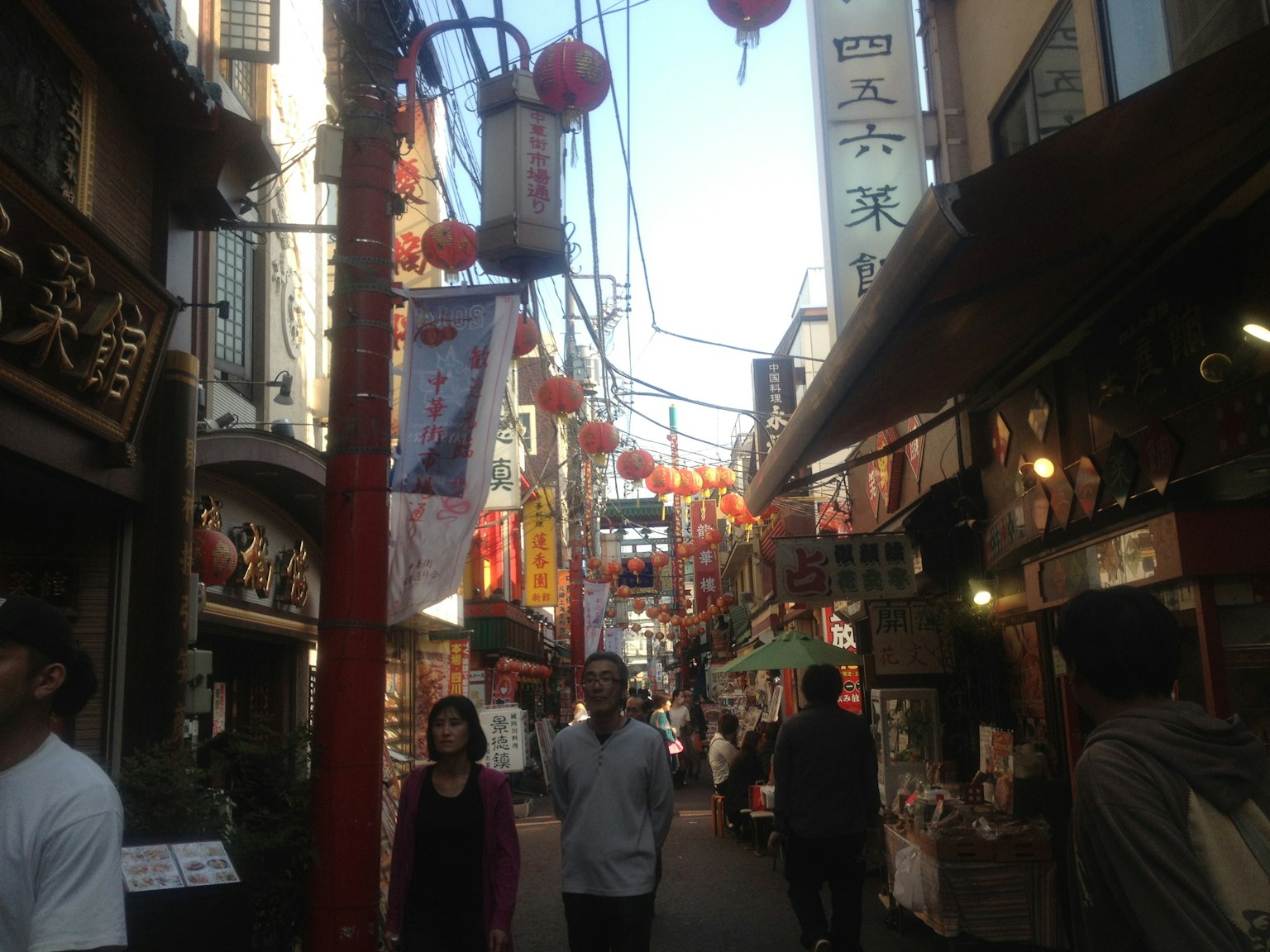 Rue animée avec des lanternes rouges et des enseignes dans un quartier commerçant