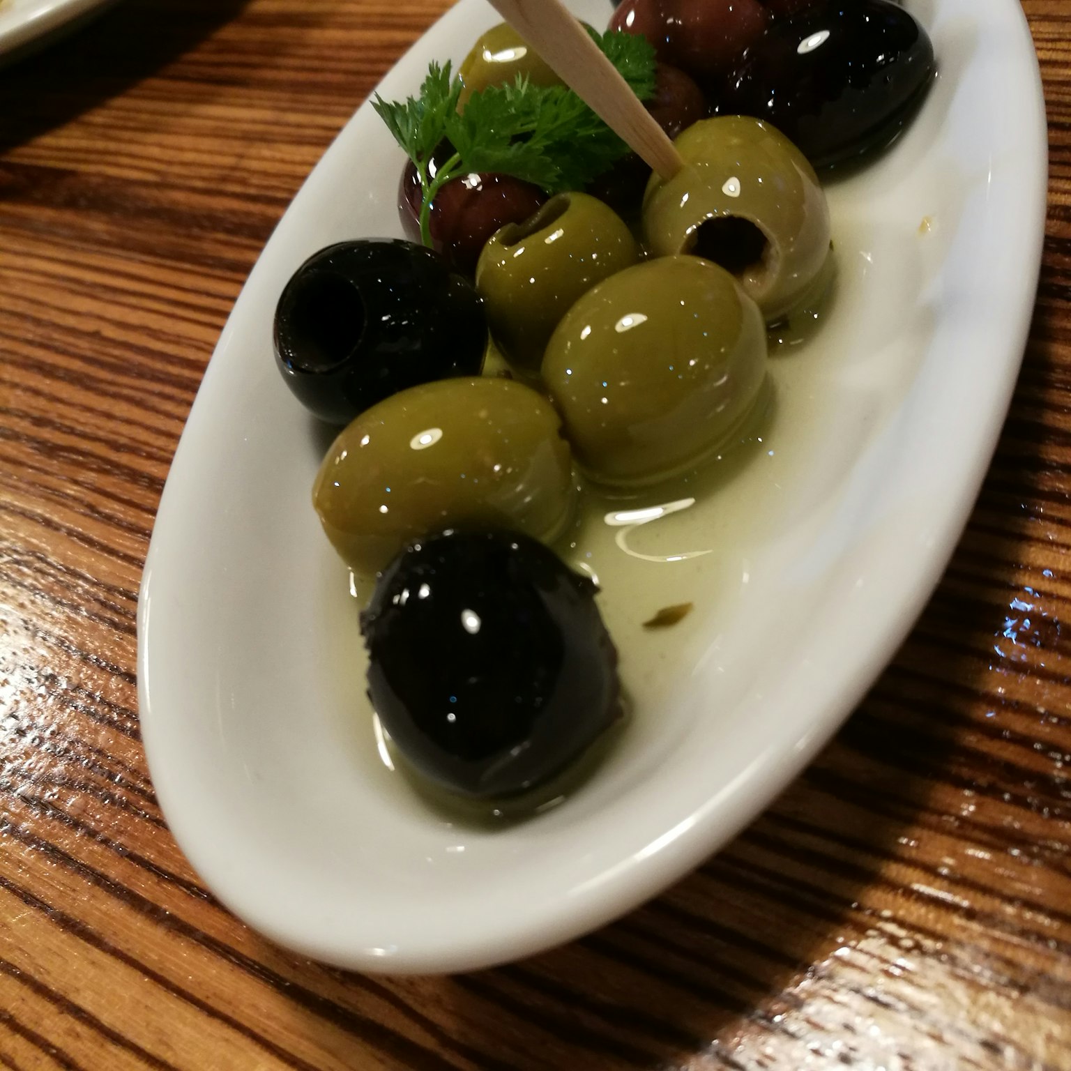 Una presentazione elegante di olive miste su un piatto bianco