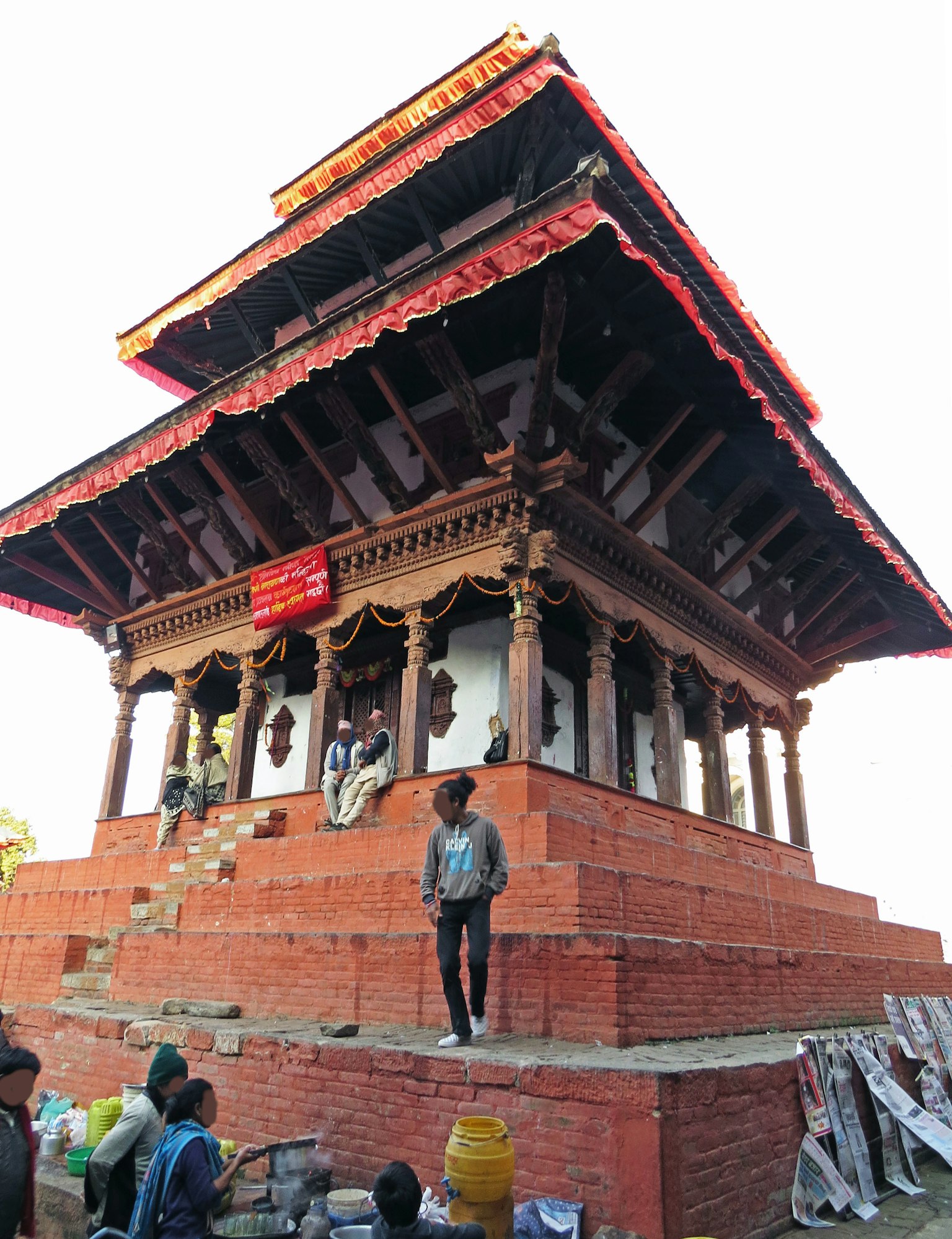 Traditioneller Tempel mit rotem Dach umgeben von Menschen