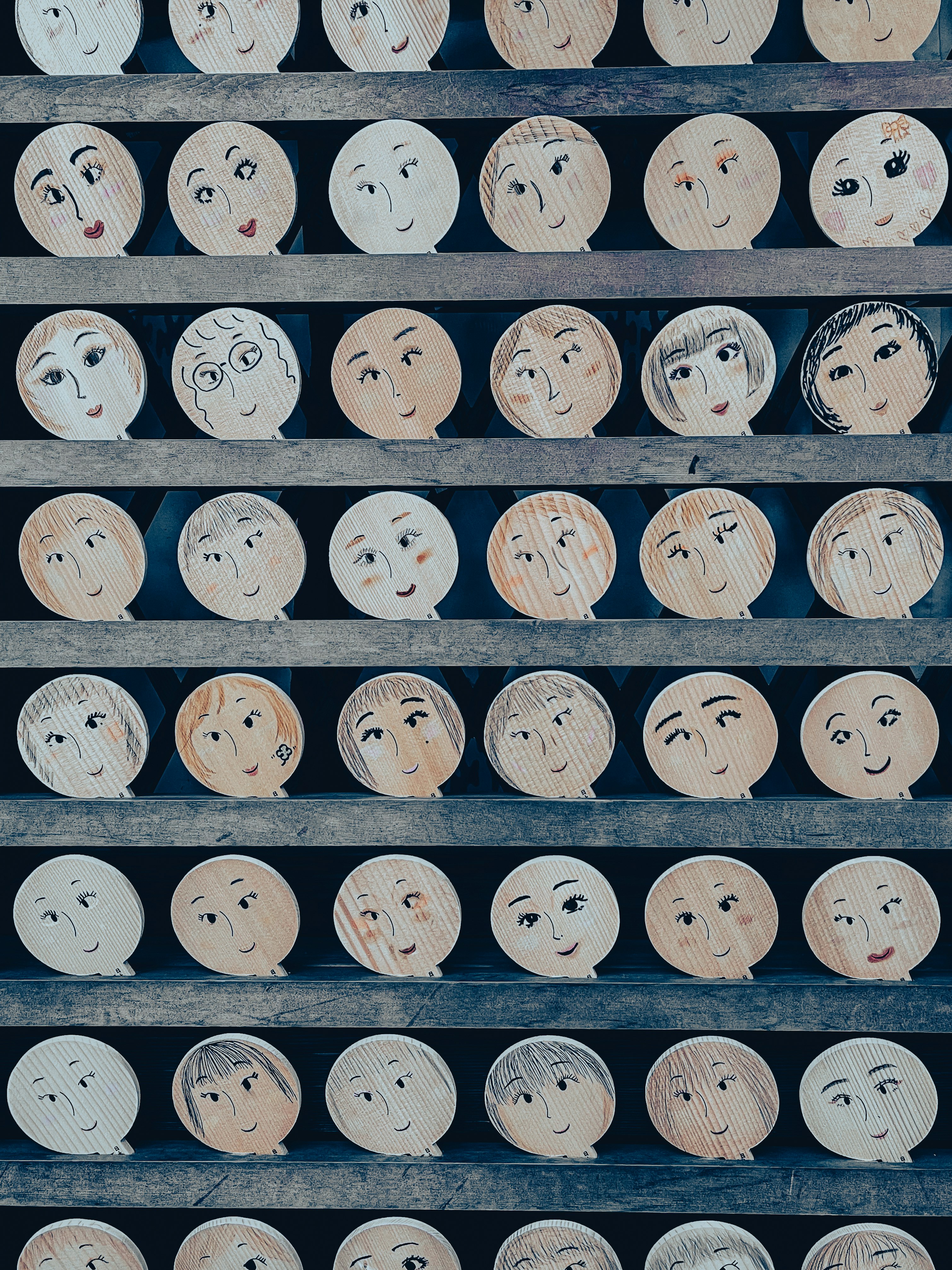 表情が描かれた丸い人形の並ぶ棚