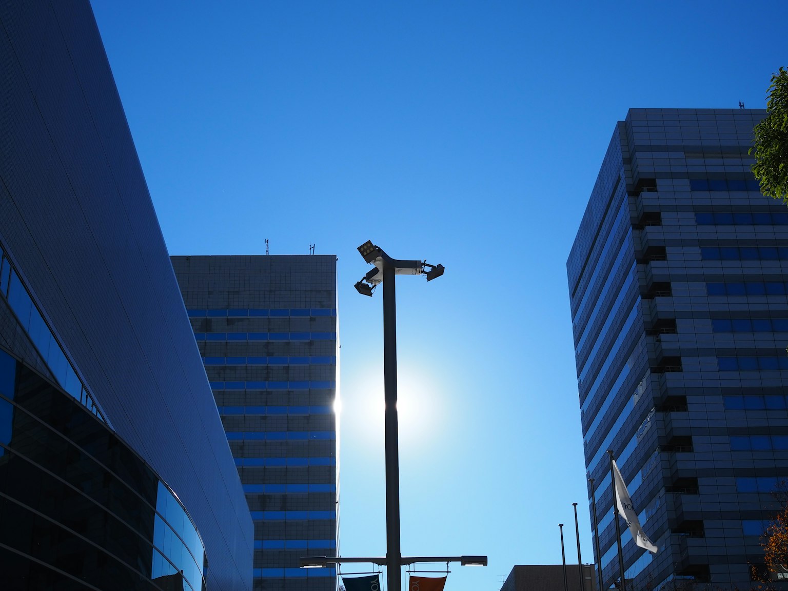 Silhouette moderner Gebäude und Straßenlaterne unter blauem Himmel
